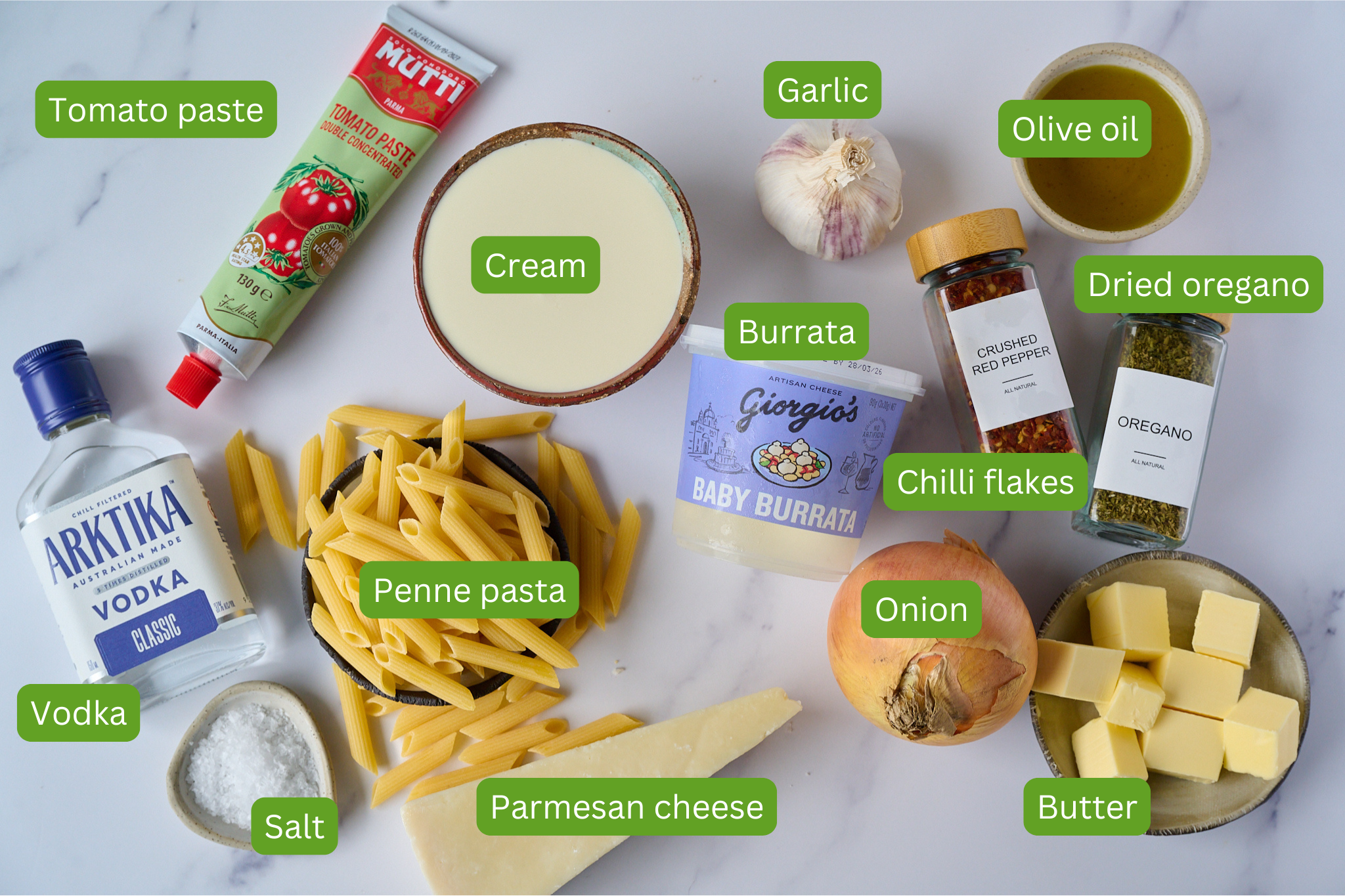 Ingredients shown for pasta all vodka that include cream, tomato paste, vodka, salt, penne pasta, parmesan cheese, onion, butter, dried oregano, chilli flakes, olive oil, garlic and burrata.