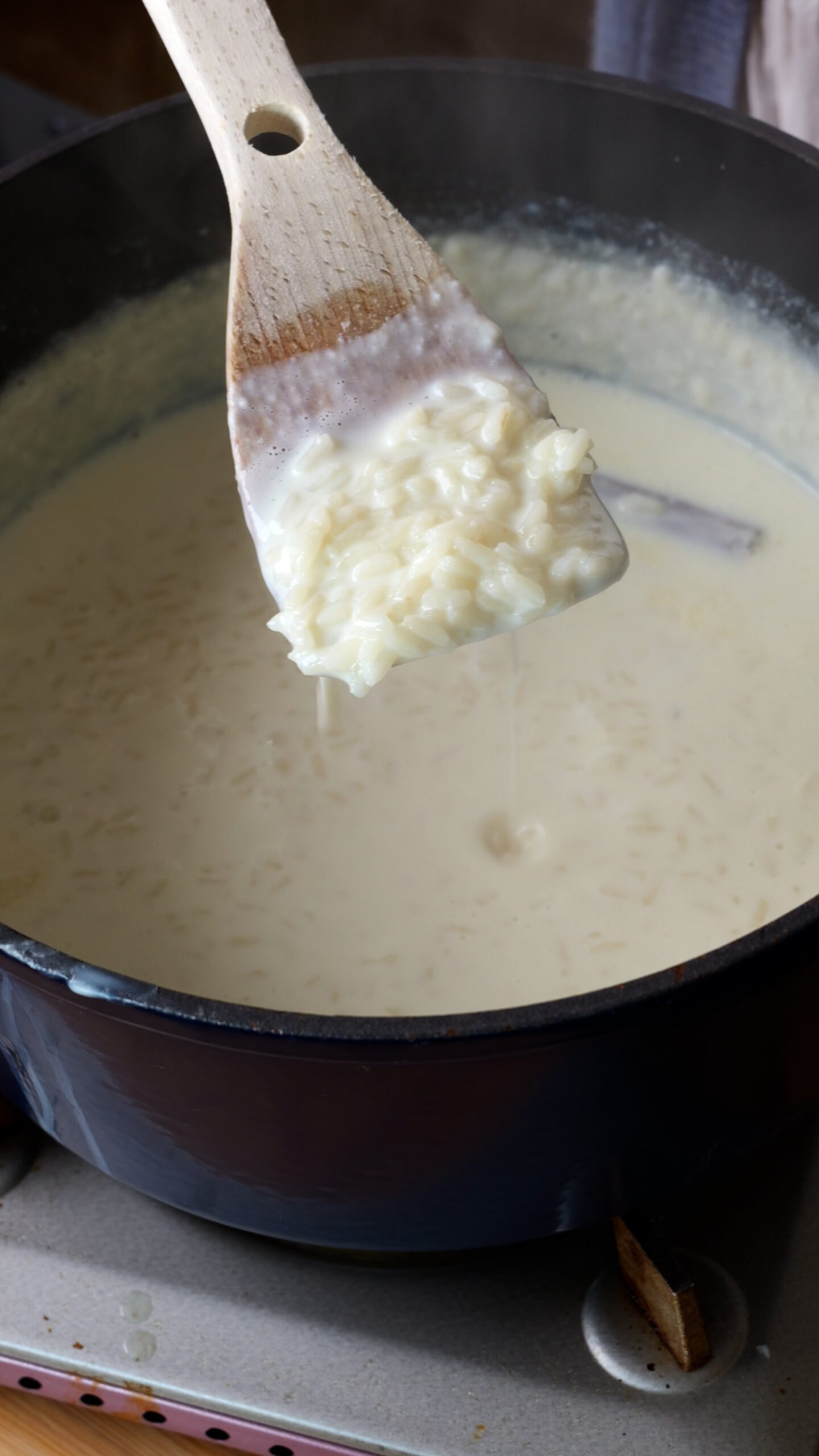 Milk and cooked rice are in a large blue pot.