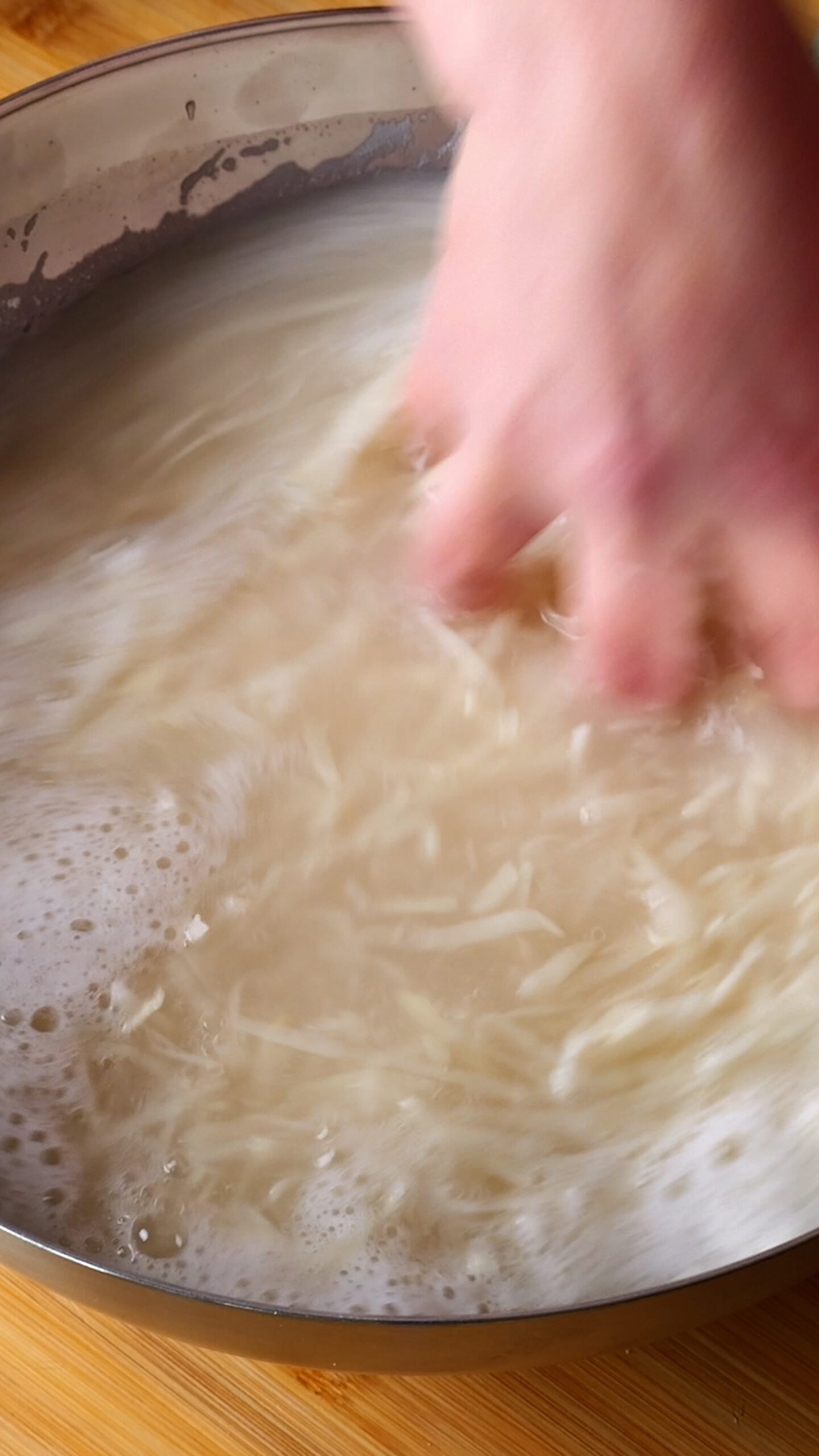 Grated potatoes are in bowl of cold water. 