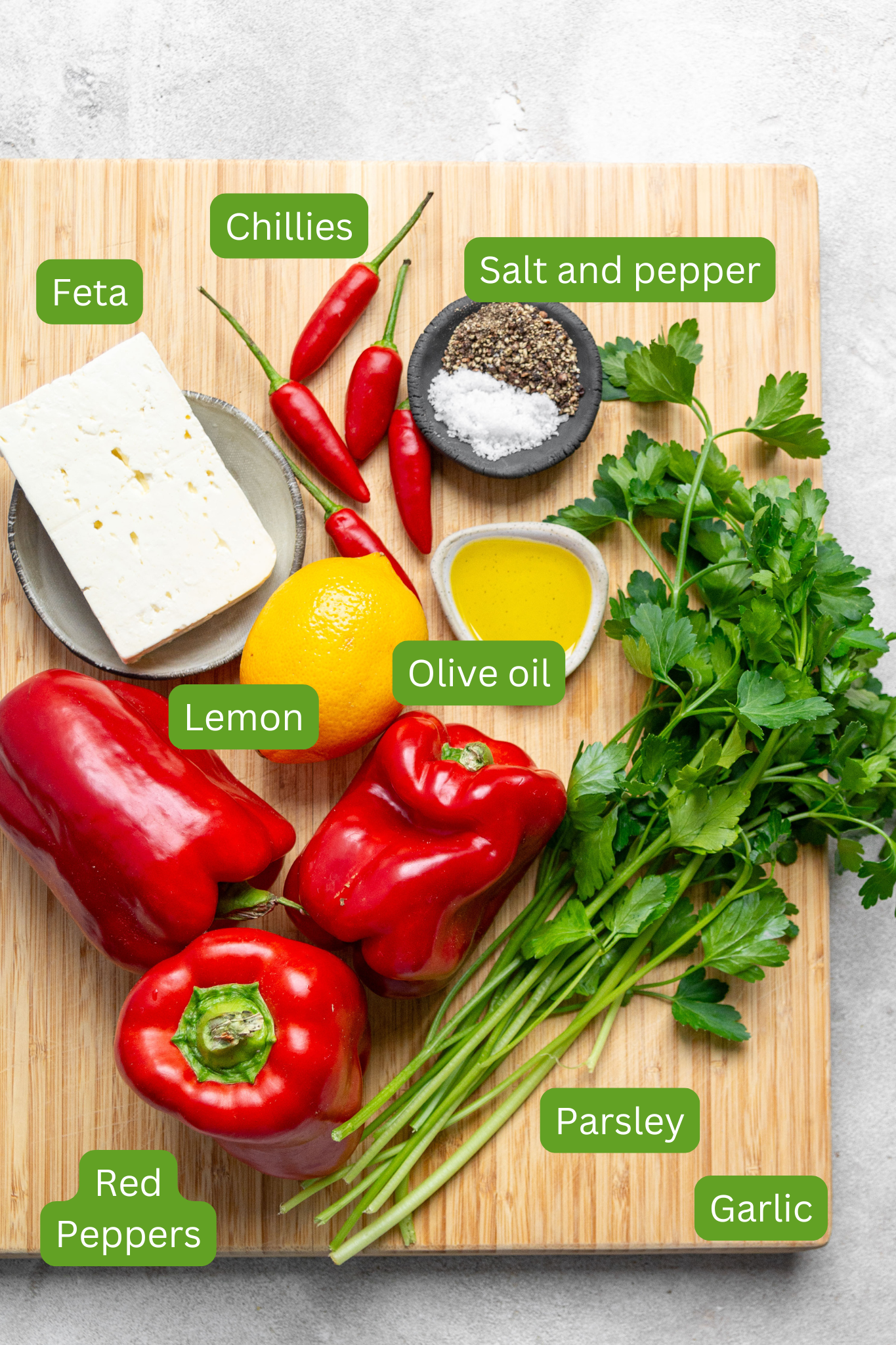 List of ingredients for this recipe. Ingredients in image include parsley, garlic, red peppers, lemon, olive oil, feta and salt and pepper. 