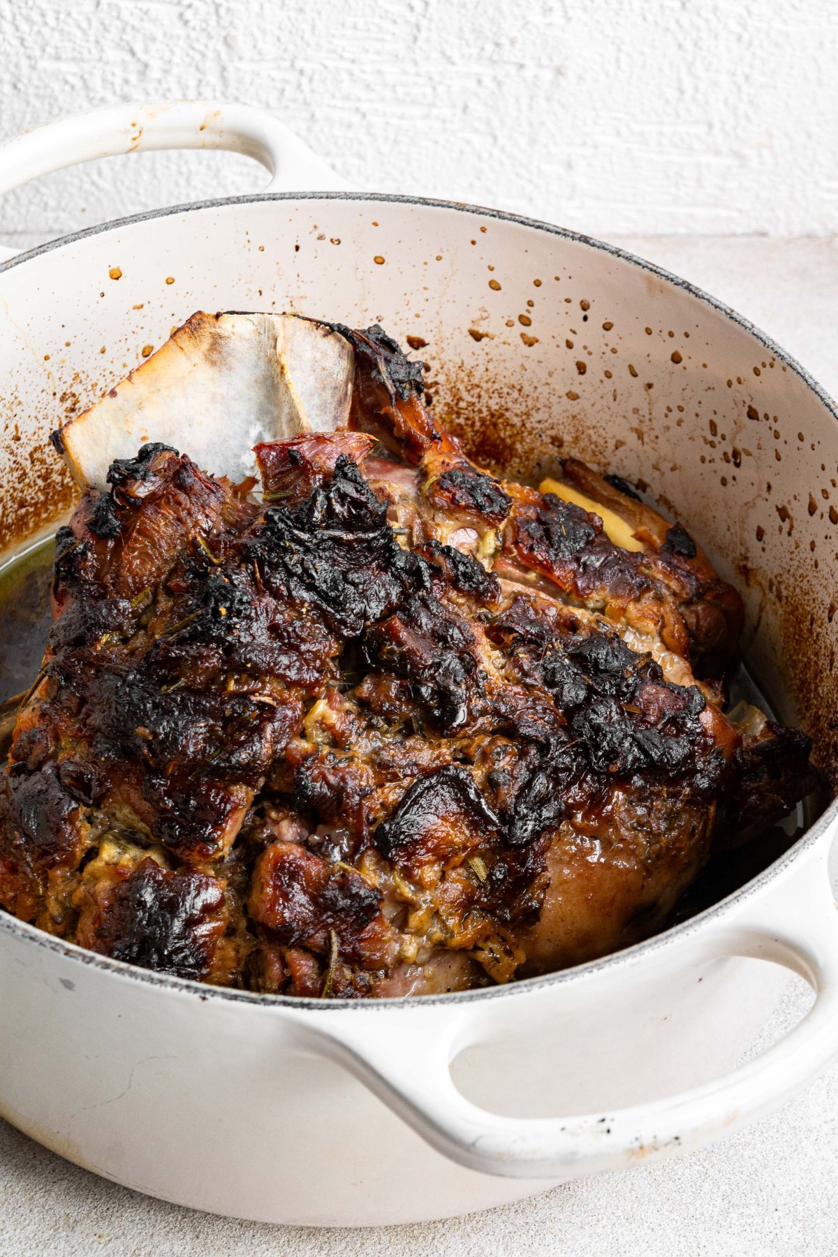 cooked lamb shoulder in large white pot