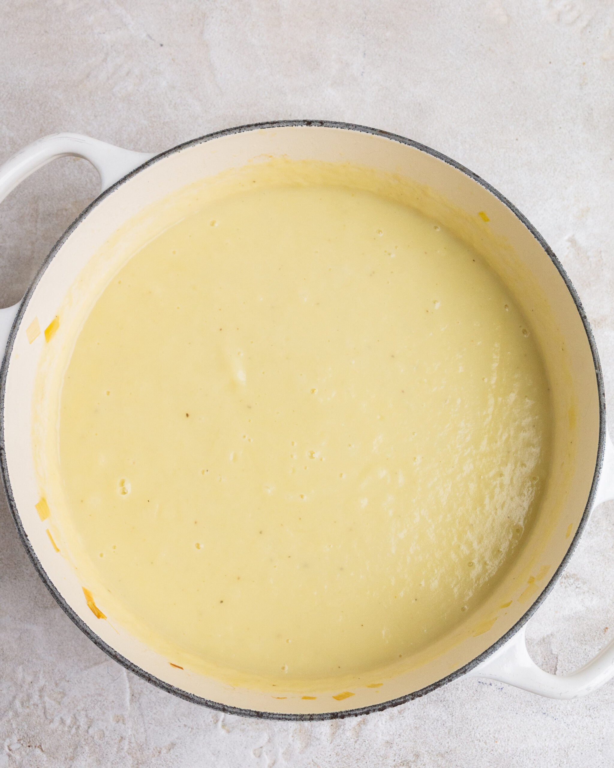 blended potato and leek soup in white bowl. 