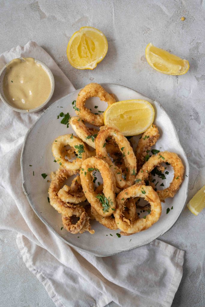 crispy fried calamari with lemon wedges and aioli