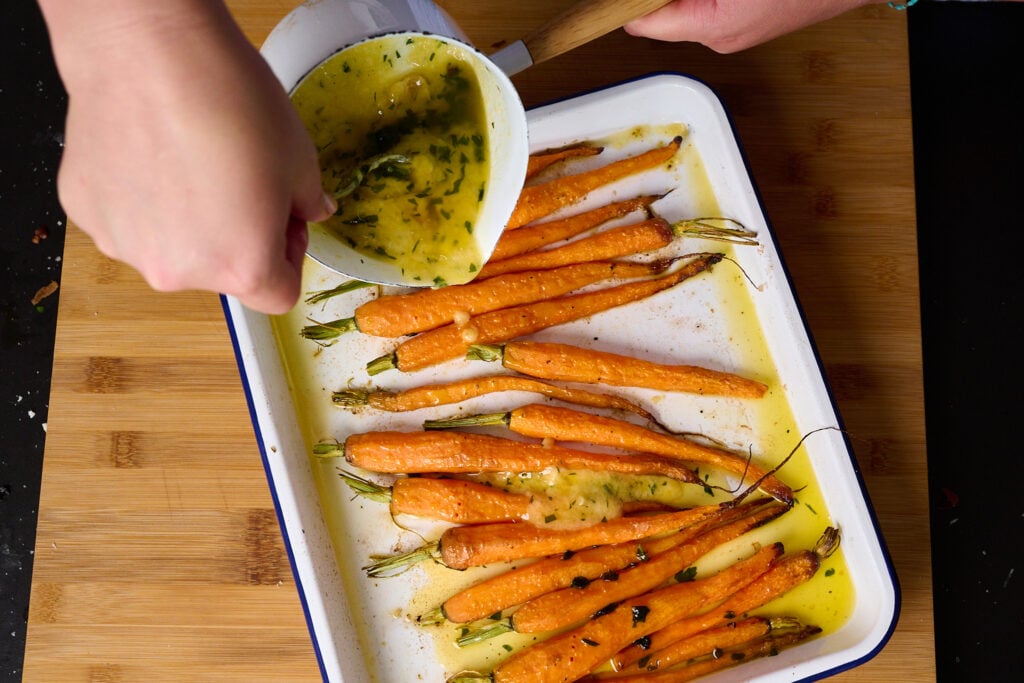 Garlic being poured into carrots