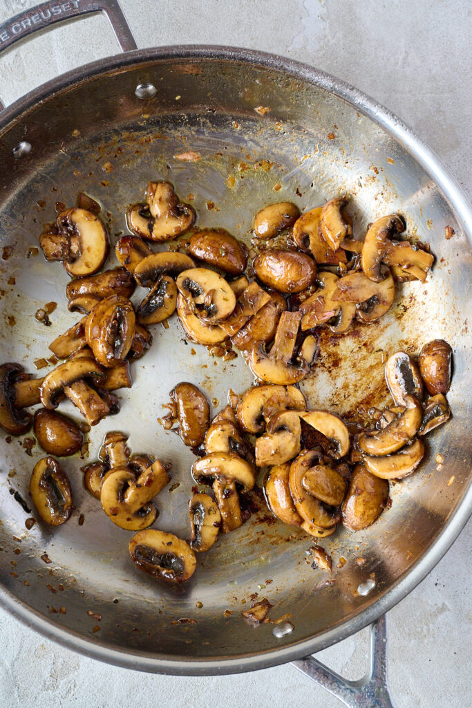 Cooked mushrooms in pan with shallots and butter