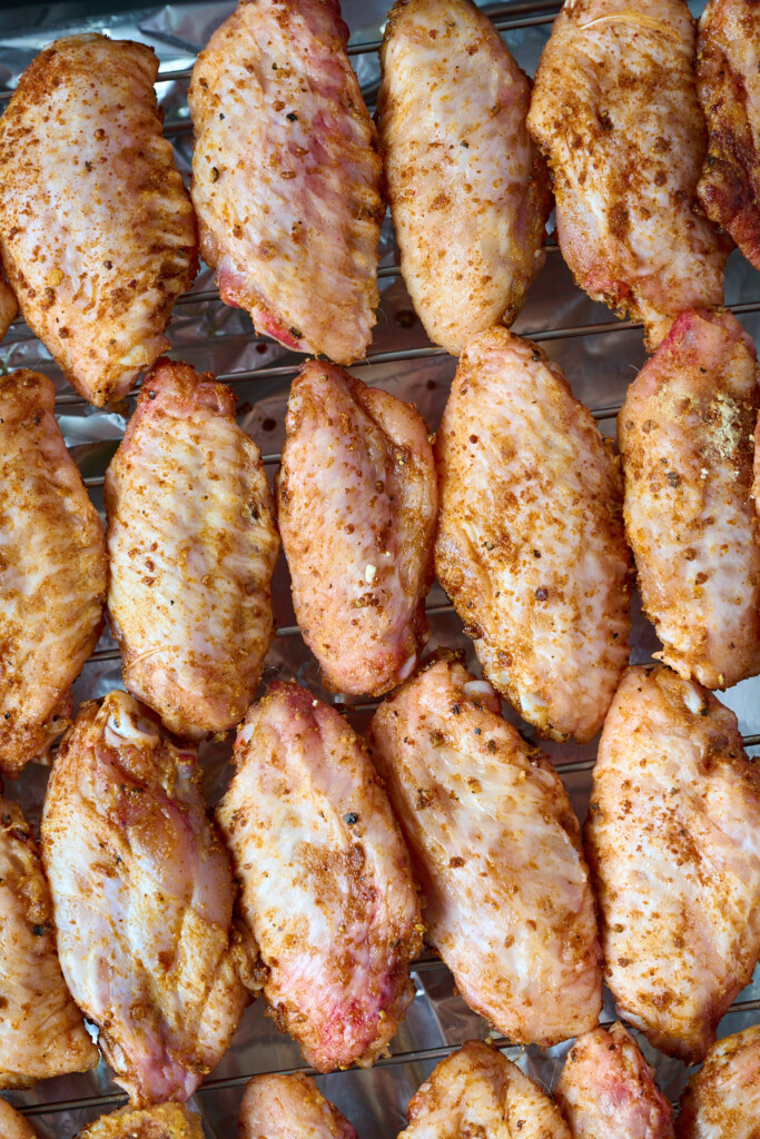 raw uncooked wings that have been seasoned lay on wire rack