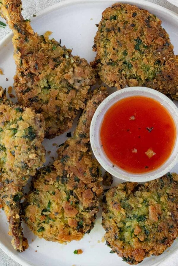 crumbed lamb cutlets with a bowl of dipping sauce.