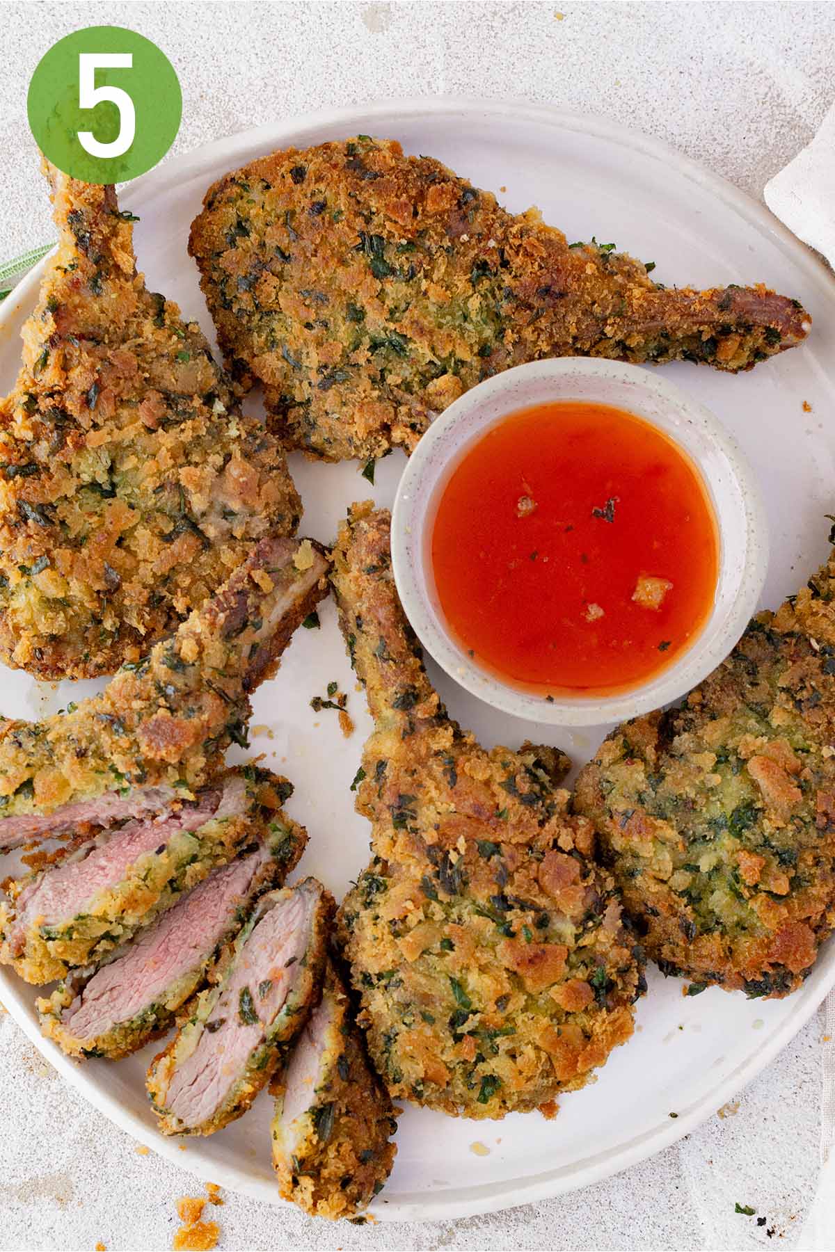 whole and sliced lamb cutlets with dipping sauce.