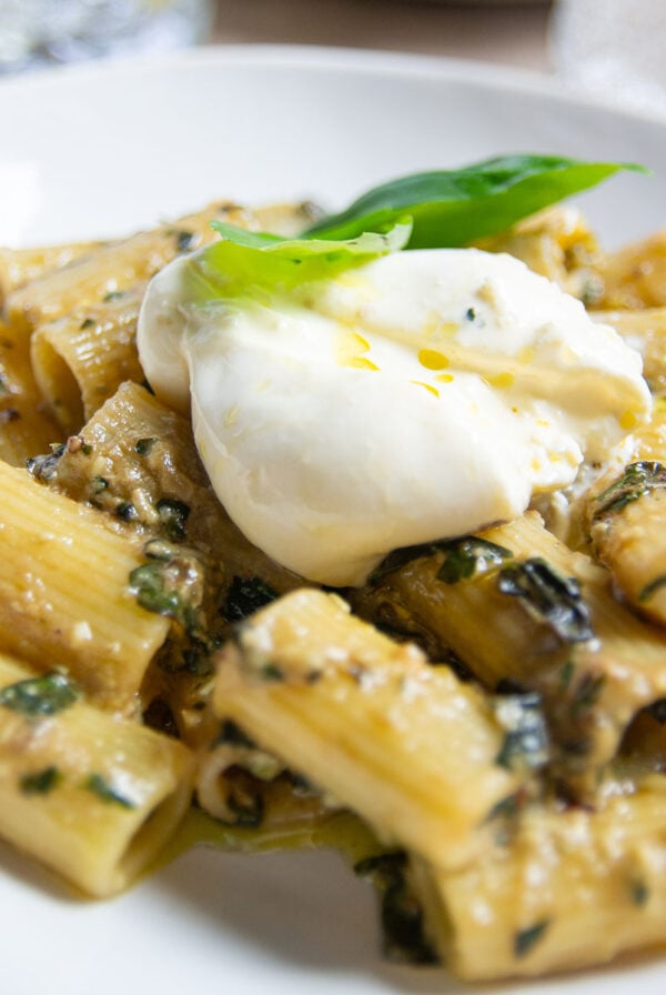 plate of garlic confit pesto pasta with garnish.