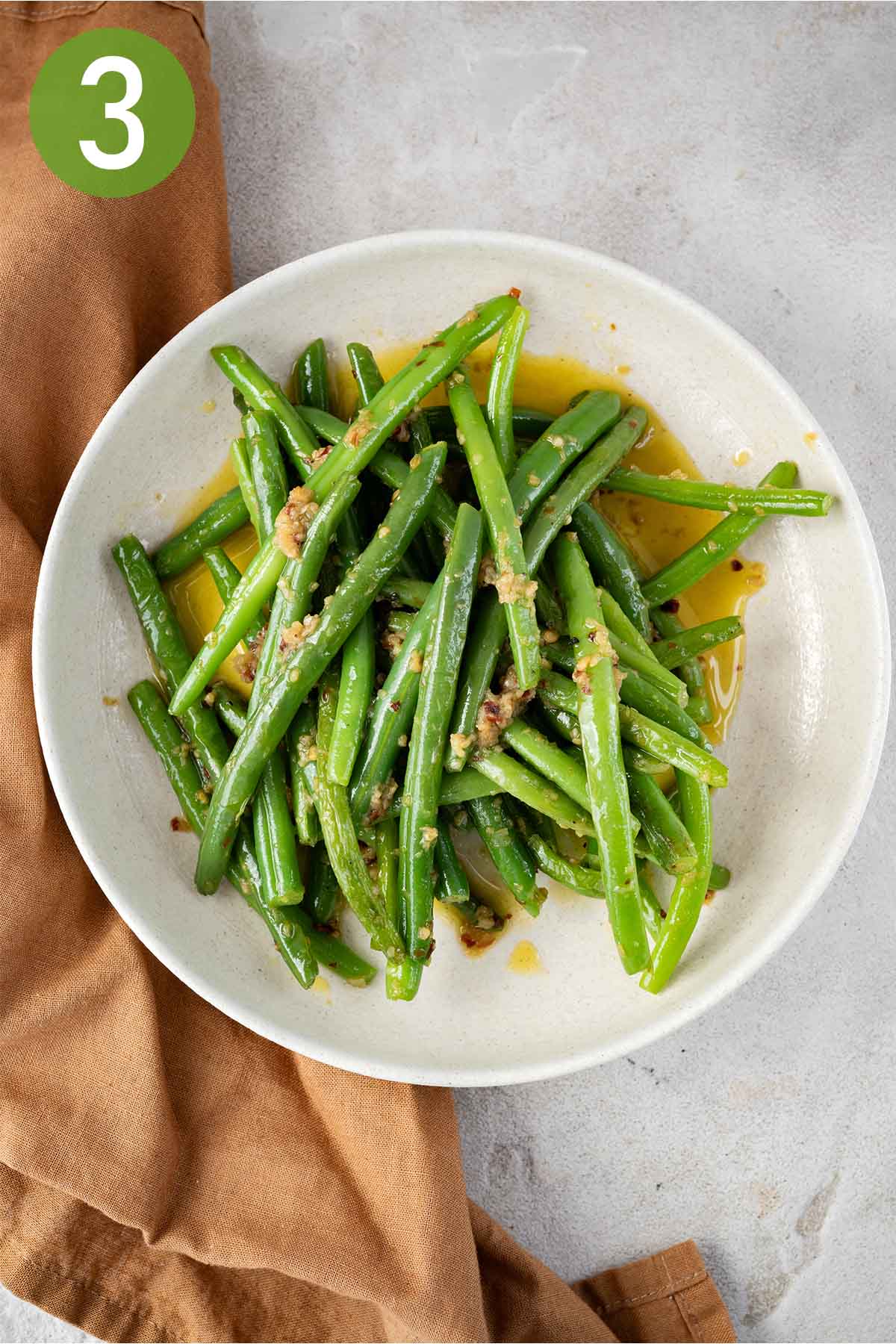 plate of garlicky green beans with a napkin.