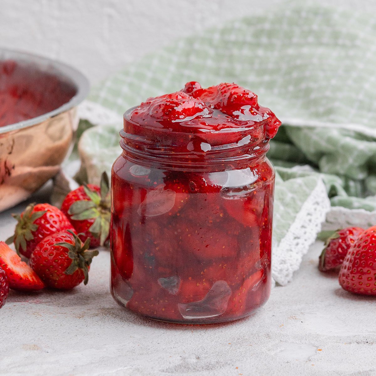 jar of strawberry jam with a green napkin.