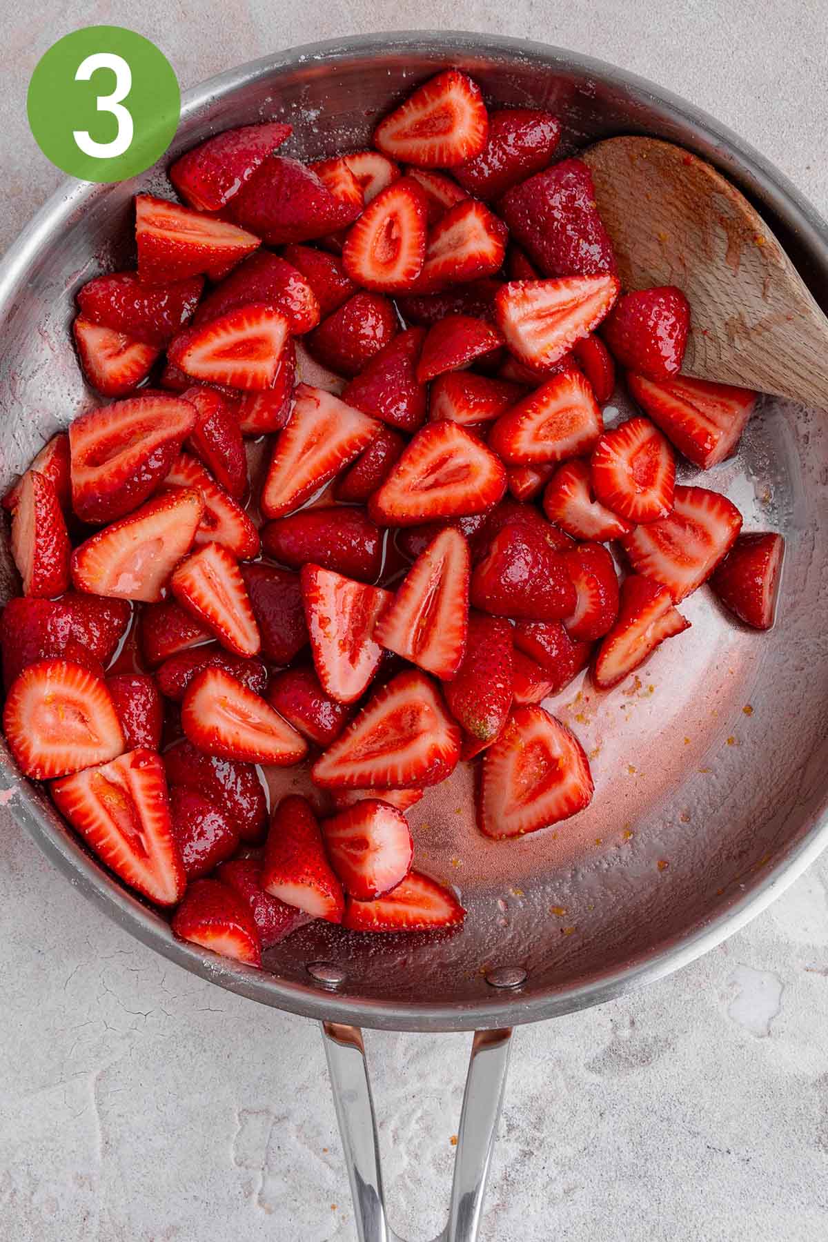 macerating strawberries in a skillet.