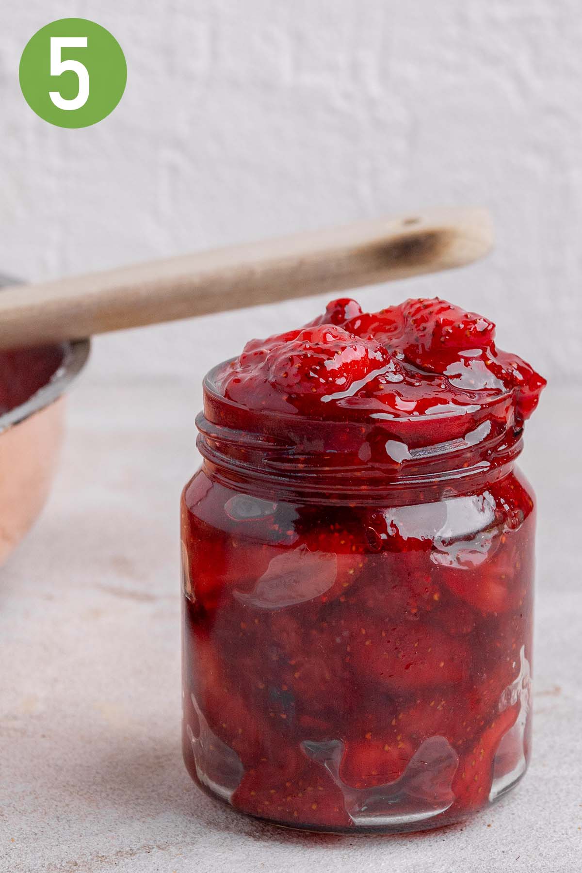 jar of strawberry jam with a wooden spoon.