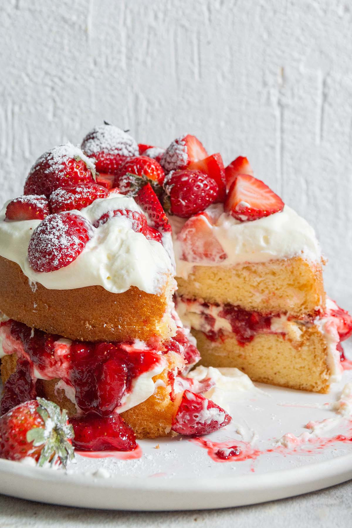 sliced strawberry jam sponge cake on a plate.