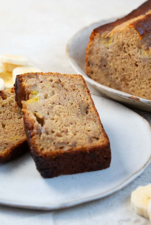 two slices of banana bread with sliced bananas.