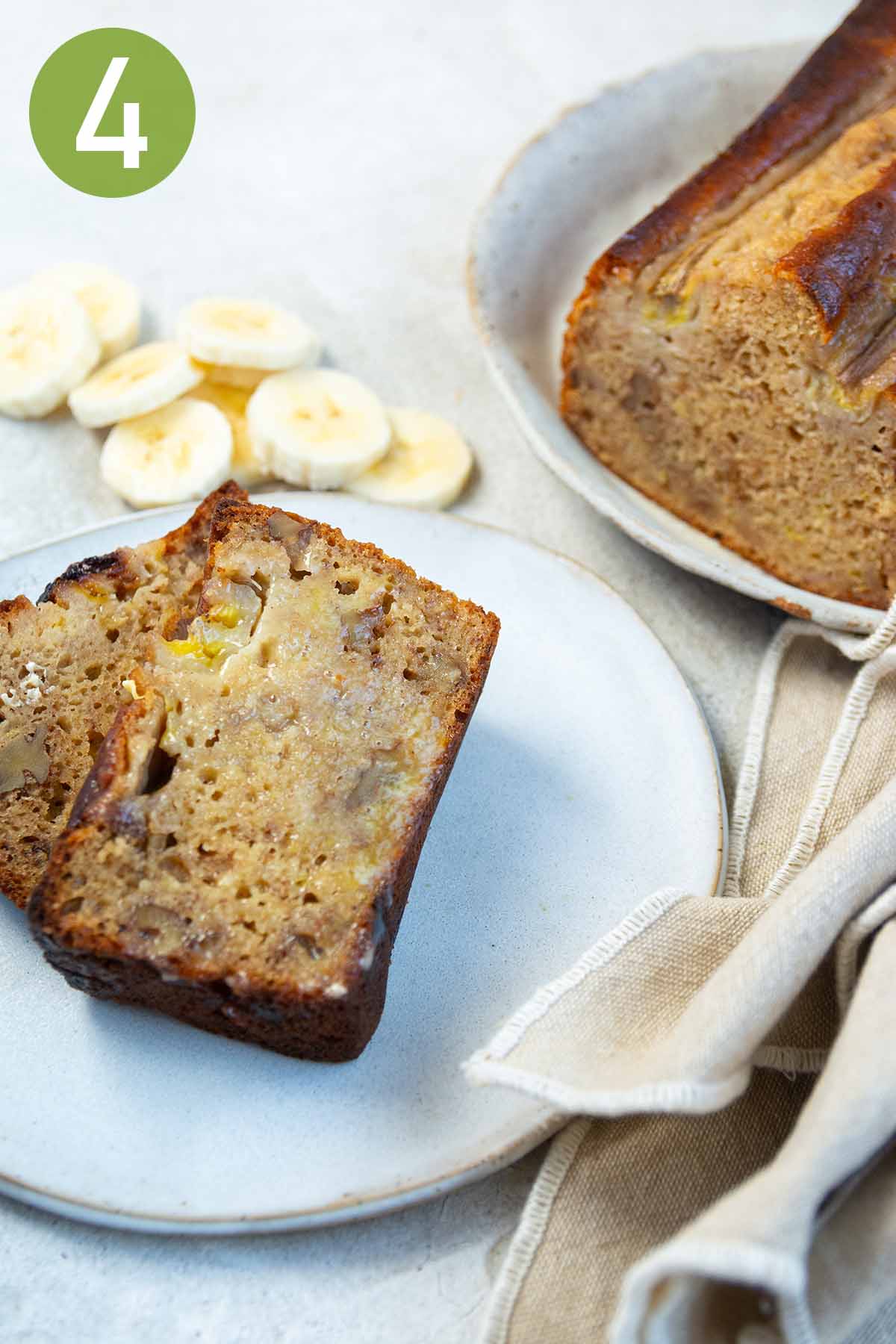 sliced banana bread on a white plate with a napkin.