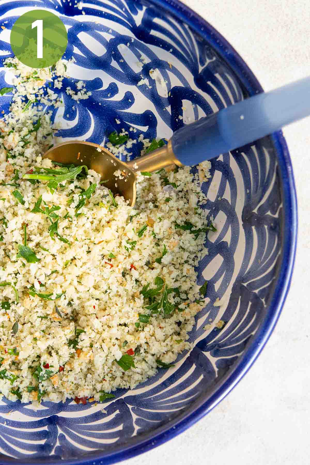 combining the herbs and breadcrumbs in a blue bowl.