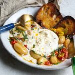 bowl of burrata with tomatoes and garlic with toast.