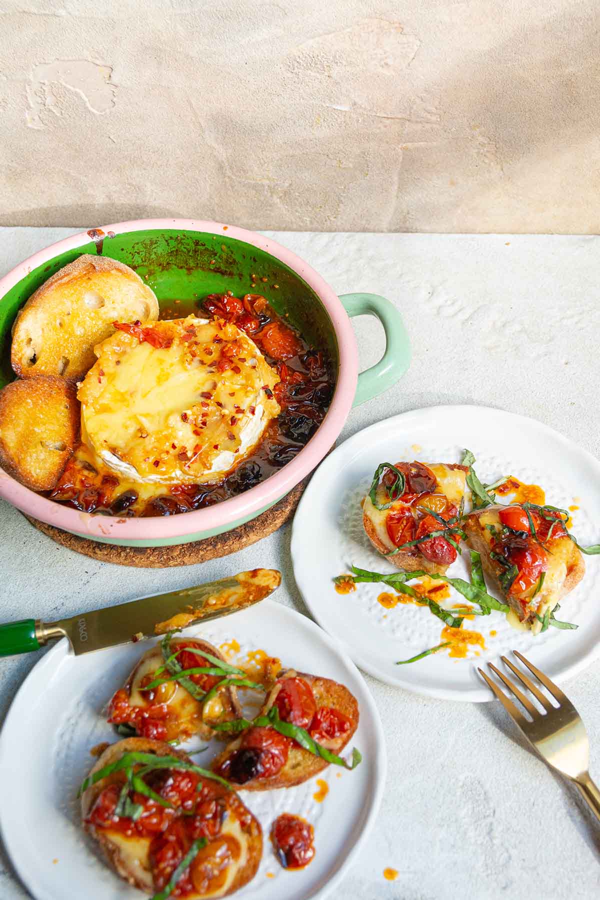roasted tomato and garlic brie with two smaller plates.