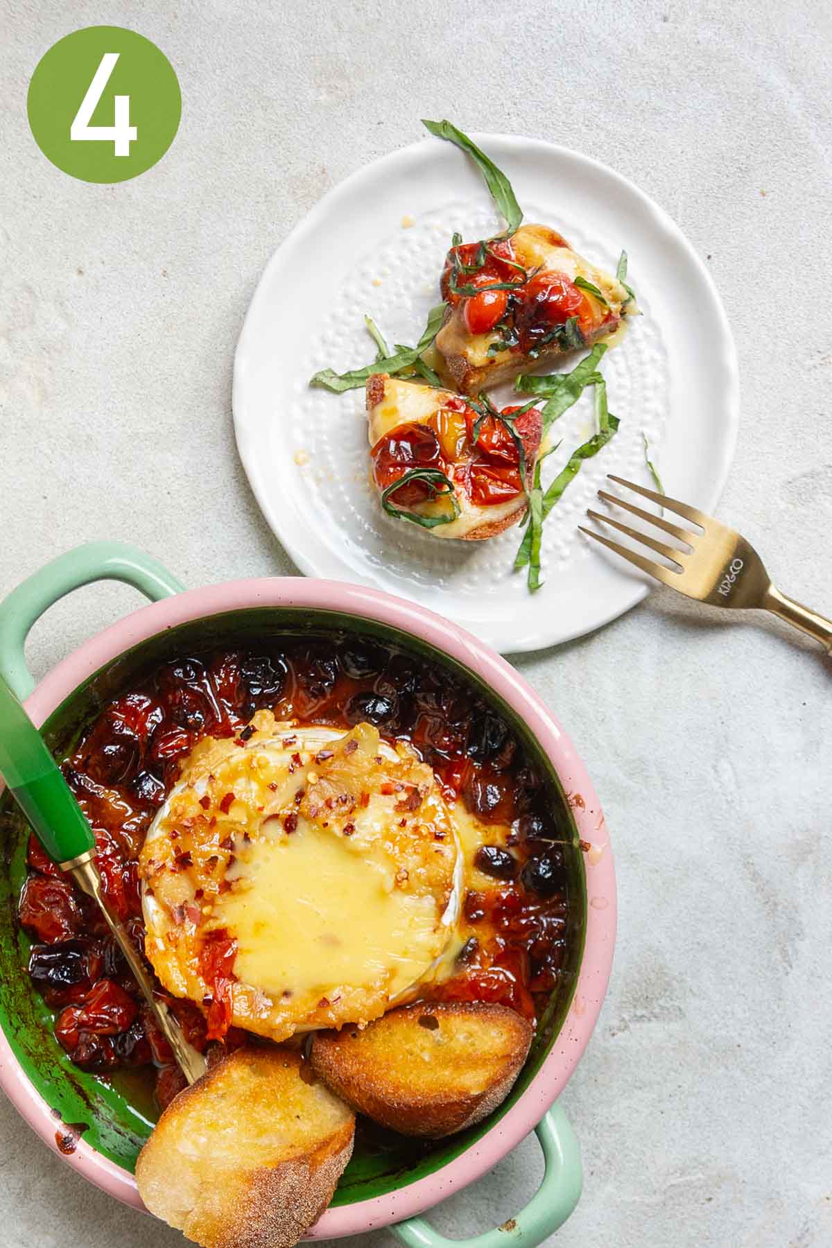 plate of melted brie with tomatoes on toasted baguette.