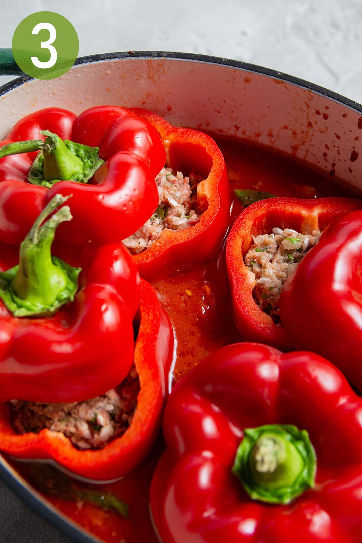 stuffing the bell peppers and putting them in the sauce.