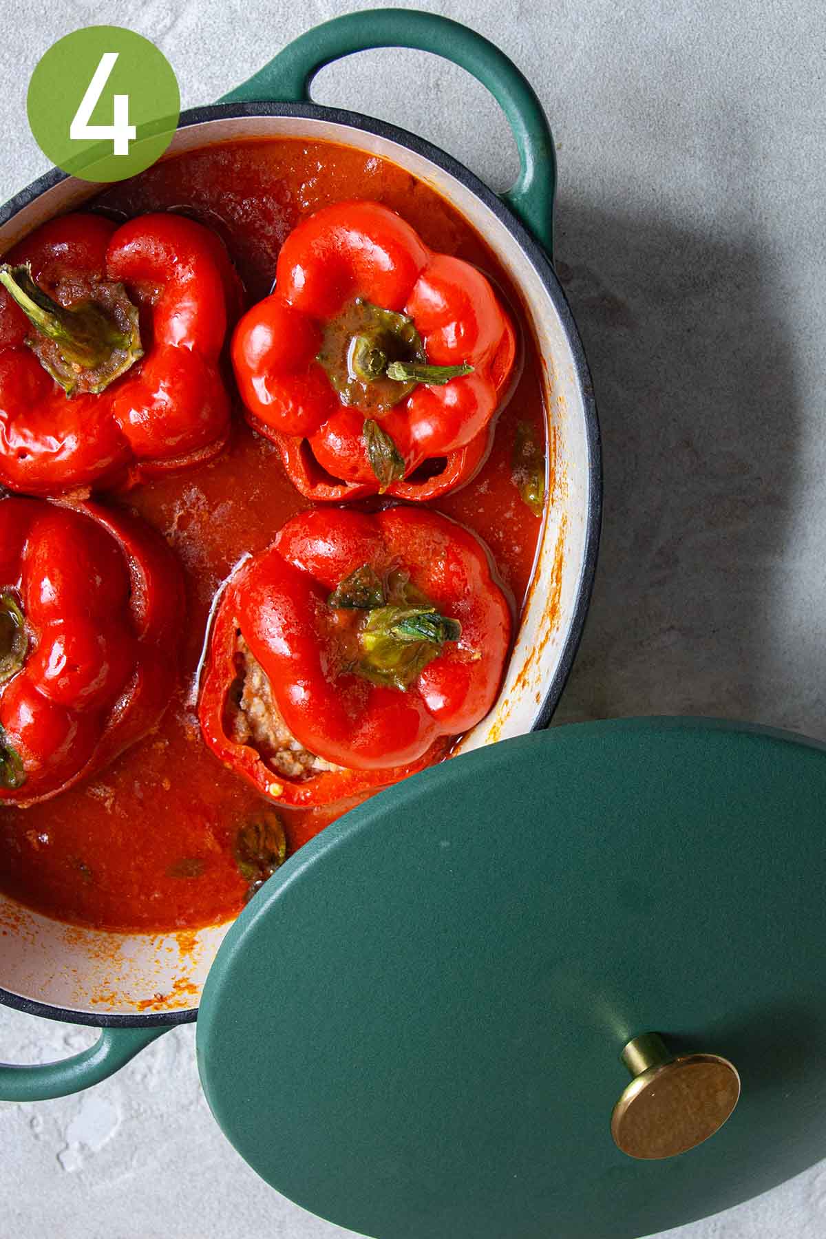 four stuffed bell peppers in a small pot.