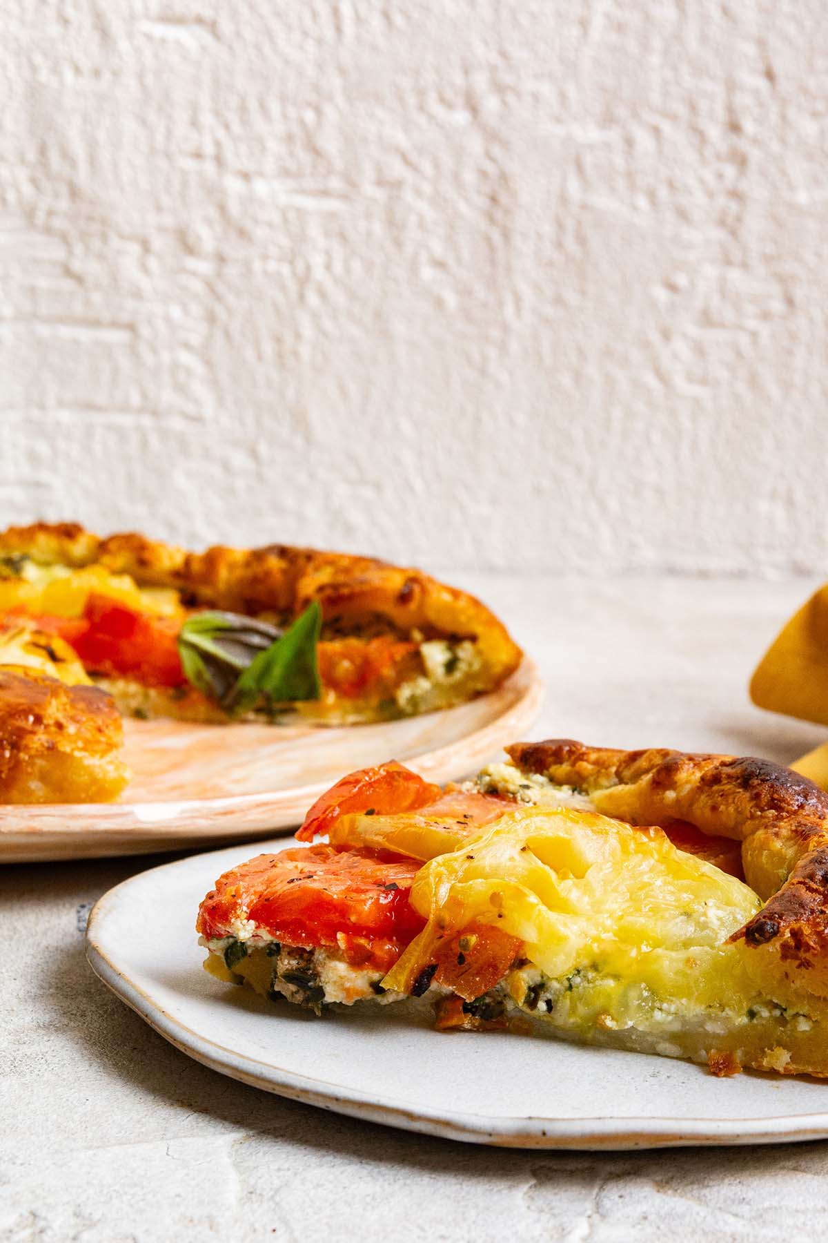 slice of summer tomato tart on a plate.
