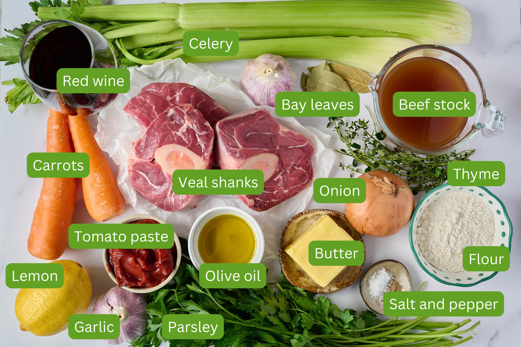 * Image of all ingredients needed for osso buco recipe. Ingredients include garlic, lemon, parsley, salt and pepper, olive oil, butter, flour, thyme, beef stock, veal shanks, tomato paste, carrots, red wine, celery, and onion.