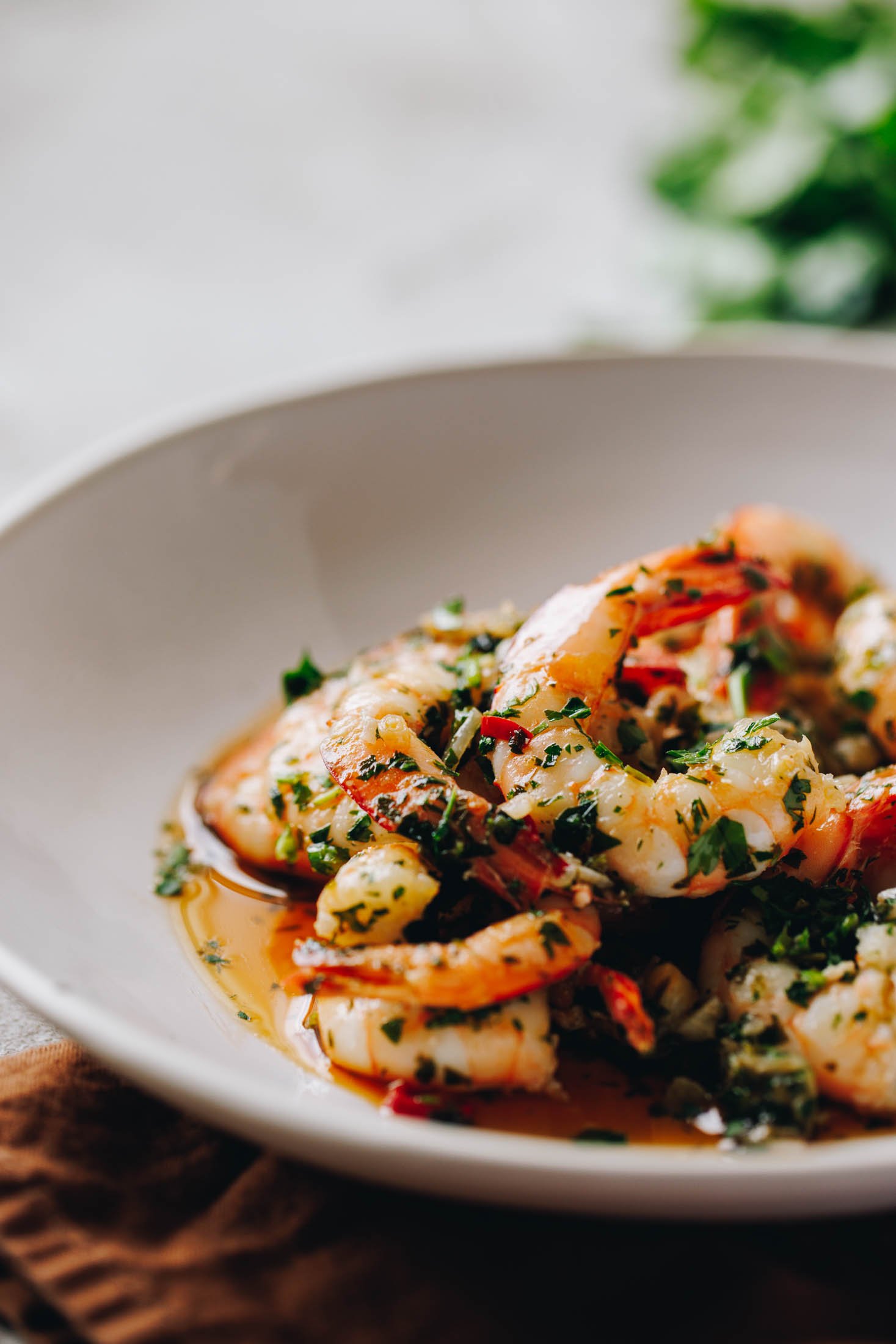 Spanish Garlic Shrimp (Prawns) - Gambas al Ajillo sit in white bowl. 