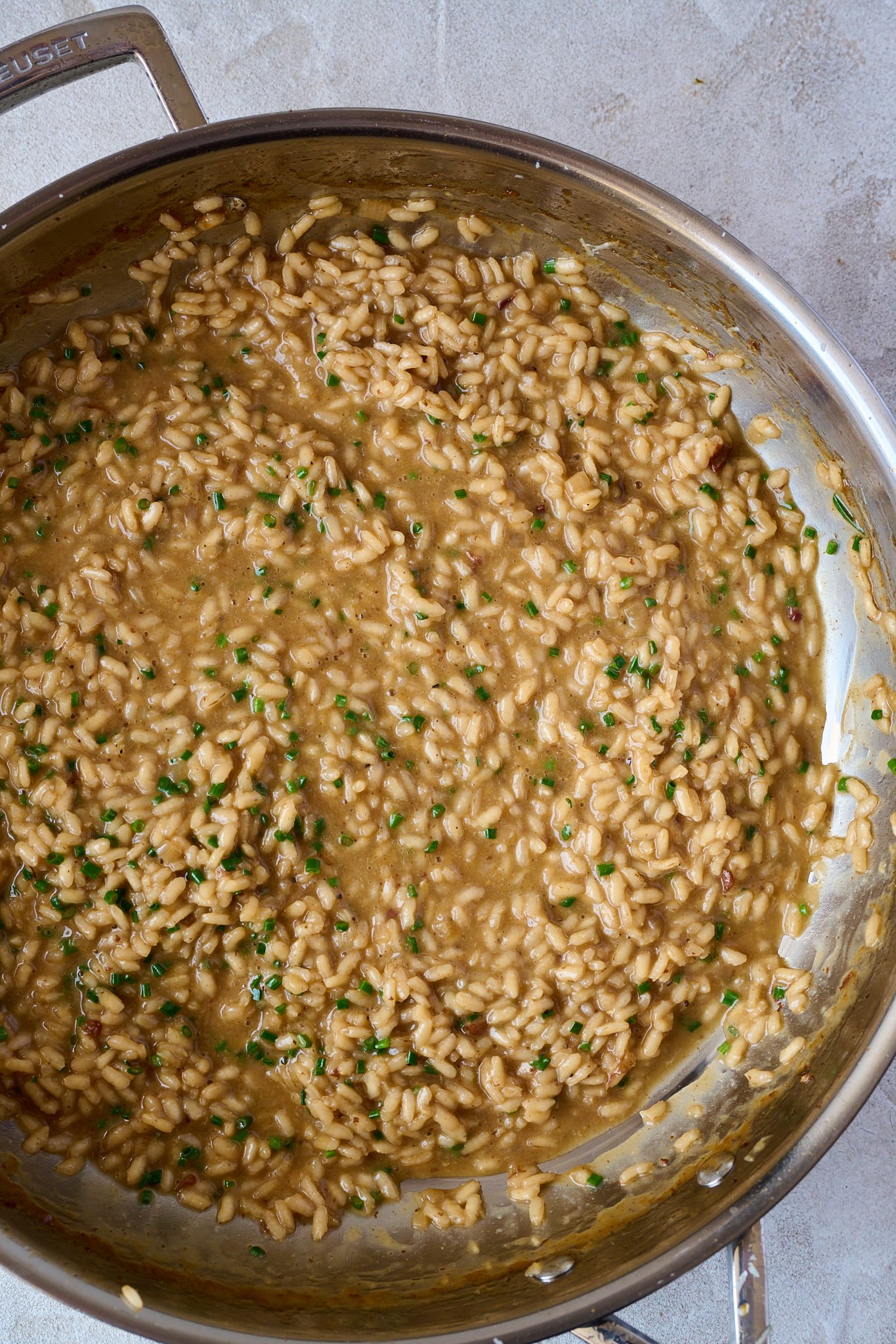 Stainless steel pan is filled with risotto. 