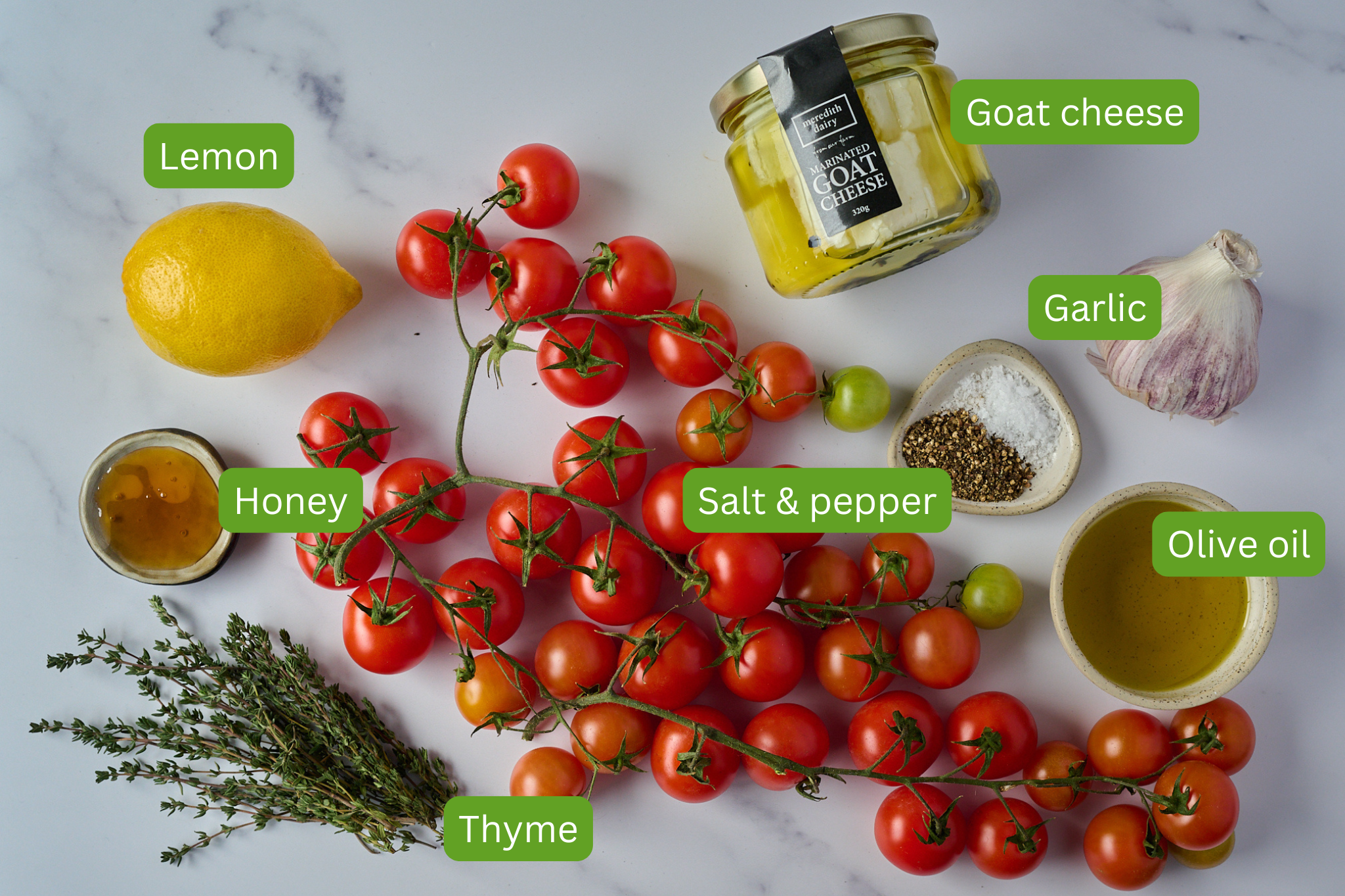 Ingredients show for roasted tomatoes and whipped goat cheese. You can see lemon, honey, thyme, cherry tomatoes on the vine, goat cheese, garlic, olive oil and salt and pepper.