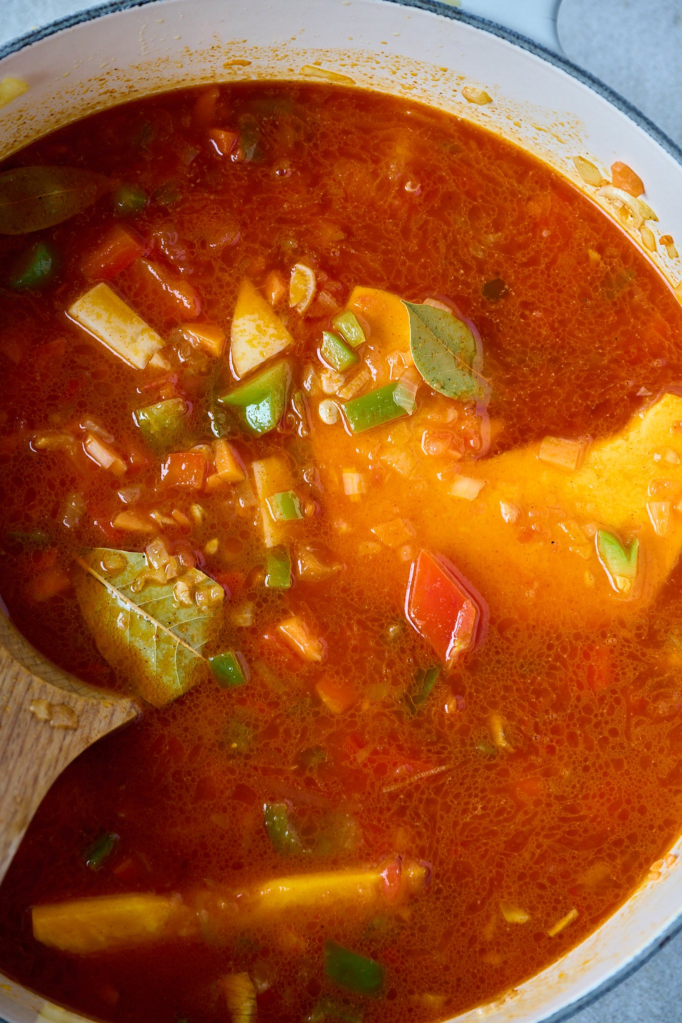 Spanish Lentil Stew (Lentejas) sits in large white pot but is not cooked yet. 