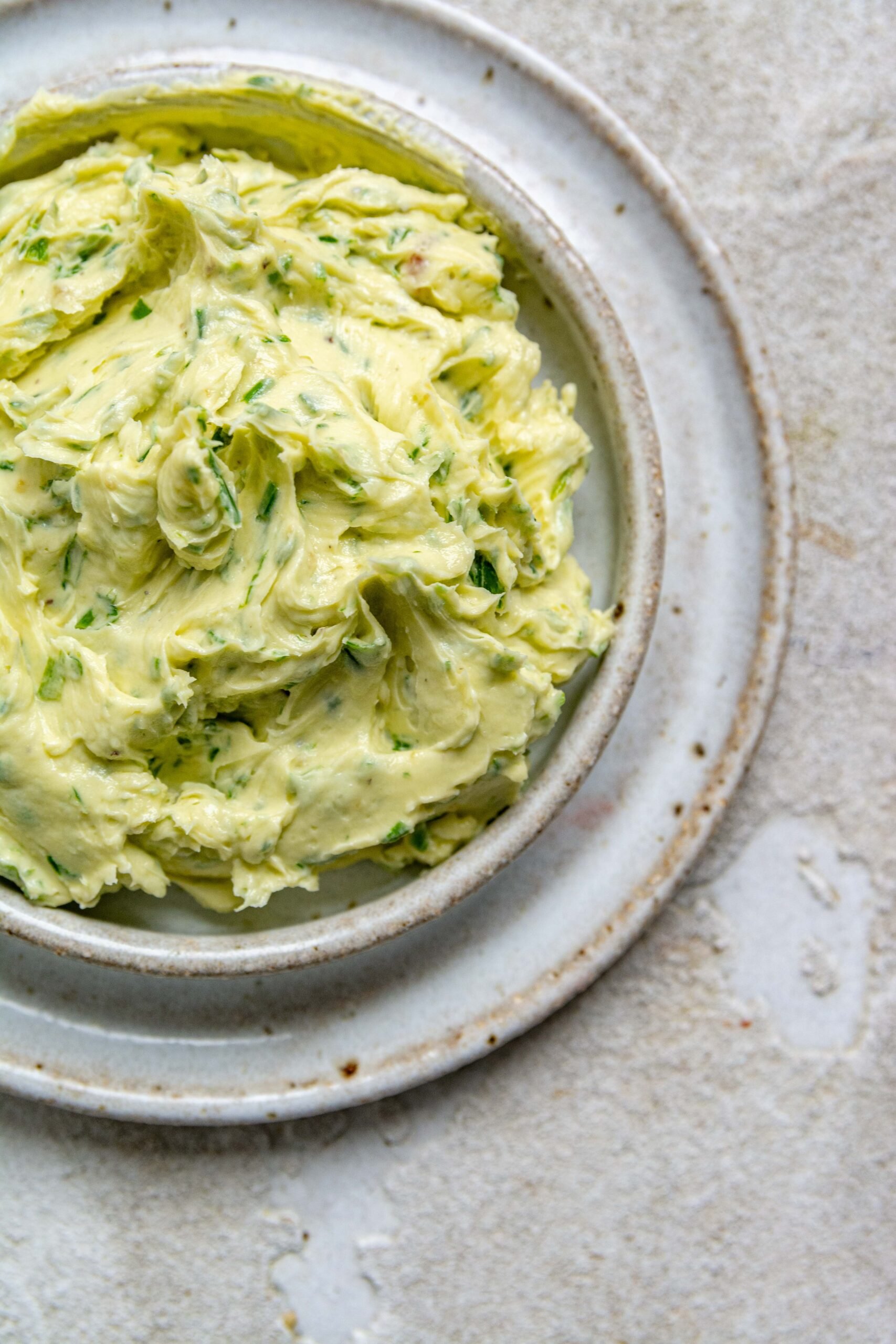Homemade garlic butter sits in small butter dish