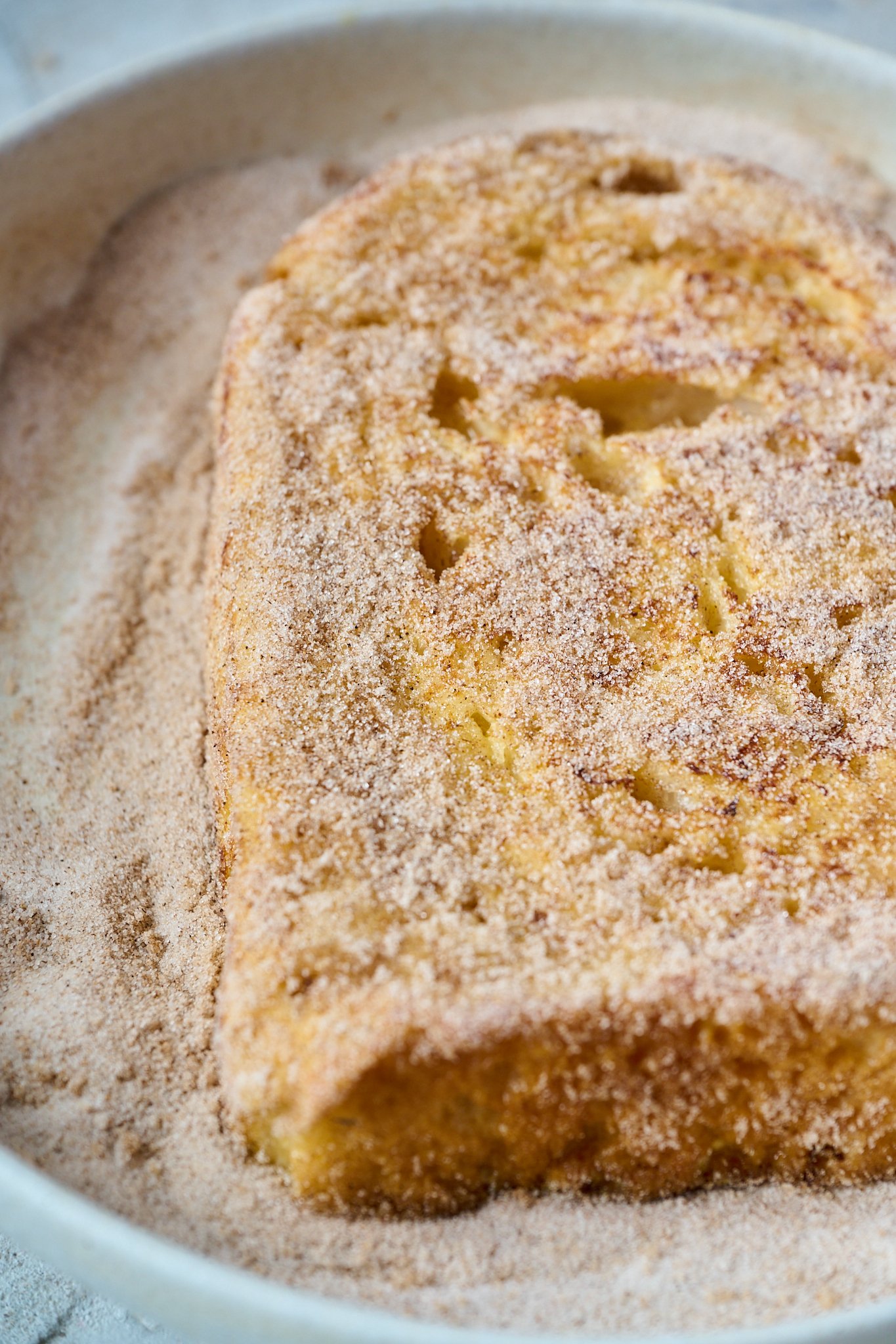 A piece of bread as been dusted with cinnamon sugar. 
