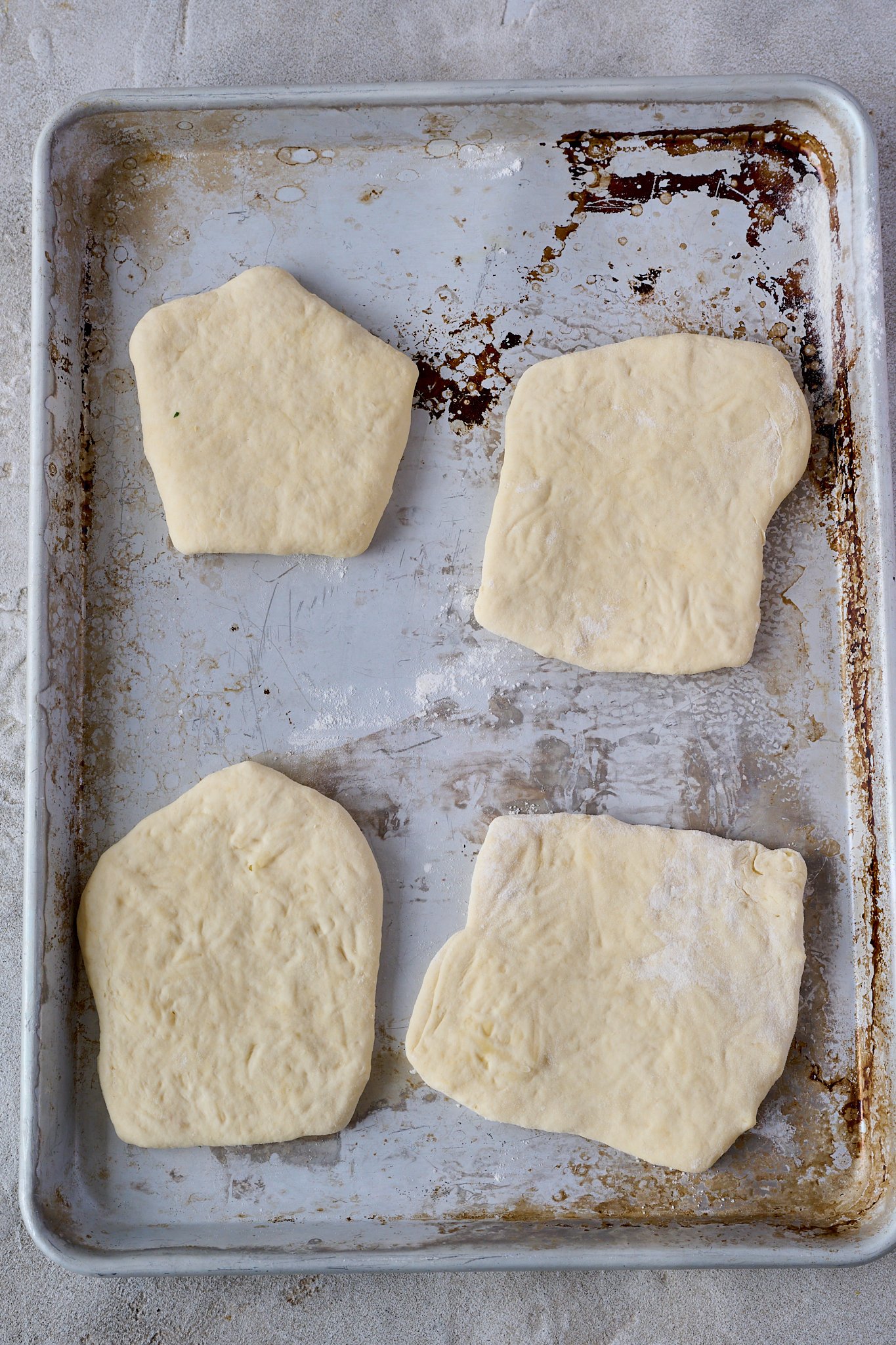 4 yogurt flatbreads sit on a stainless steel baking tray
