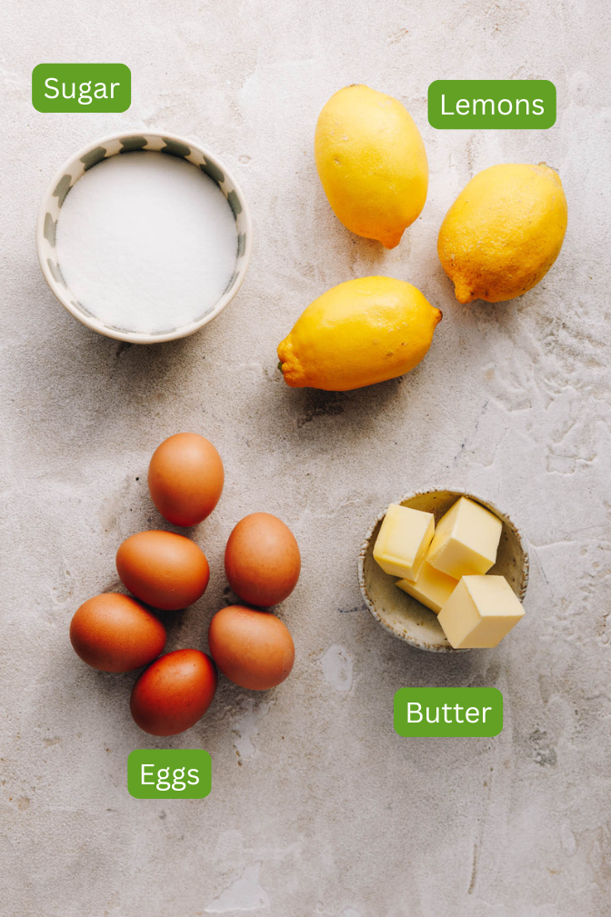 Ingredients shown from homemade lemon curd. Include sugar, 3 lemons, eggs and butter.