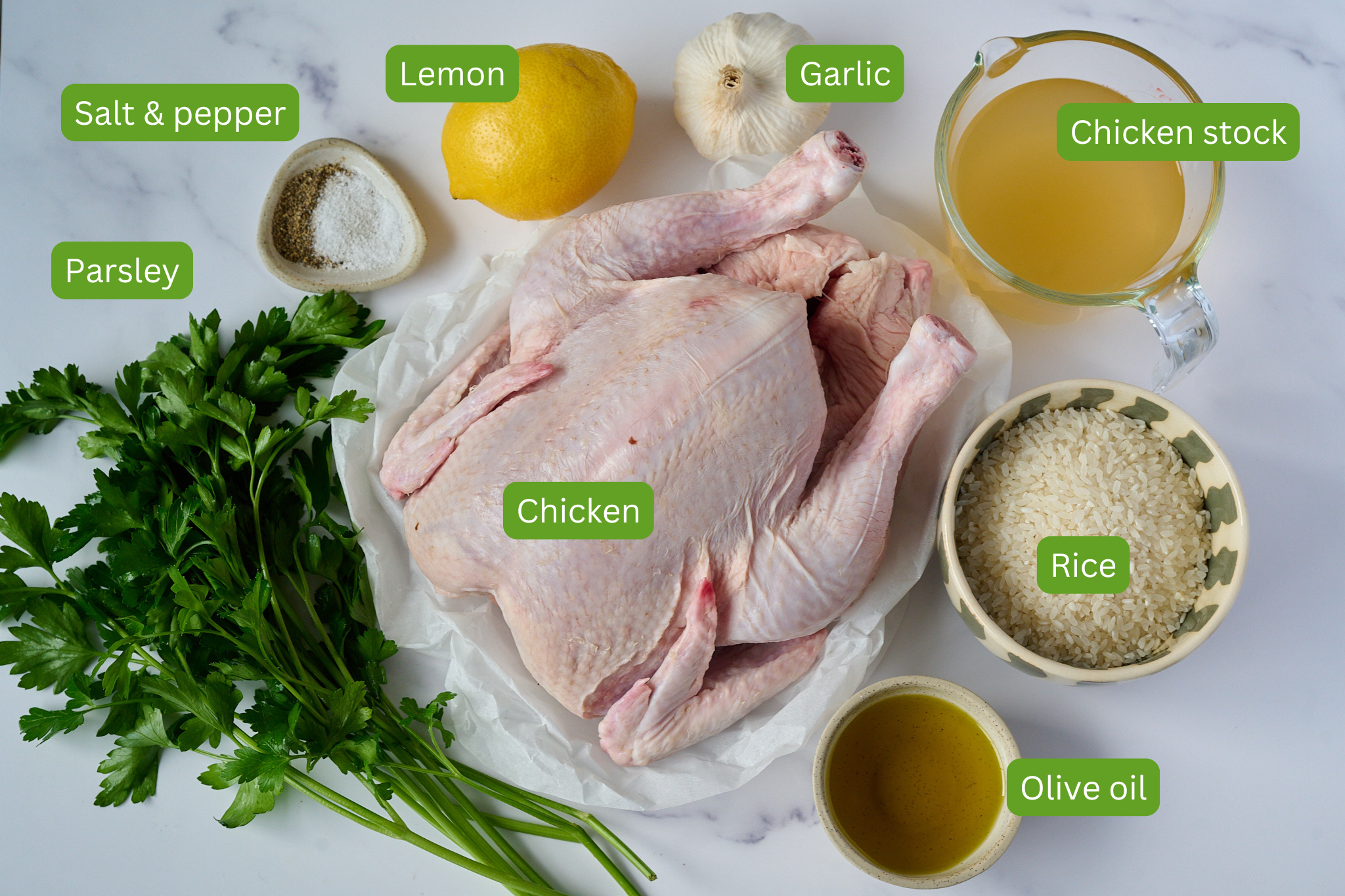 Ingredients for one pan chicken and rice are shown. You can see chicken stock, rice, olive oil, chicken, garlic, lemon, salt and pepper and parsley.