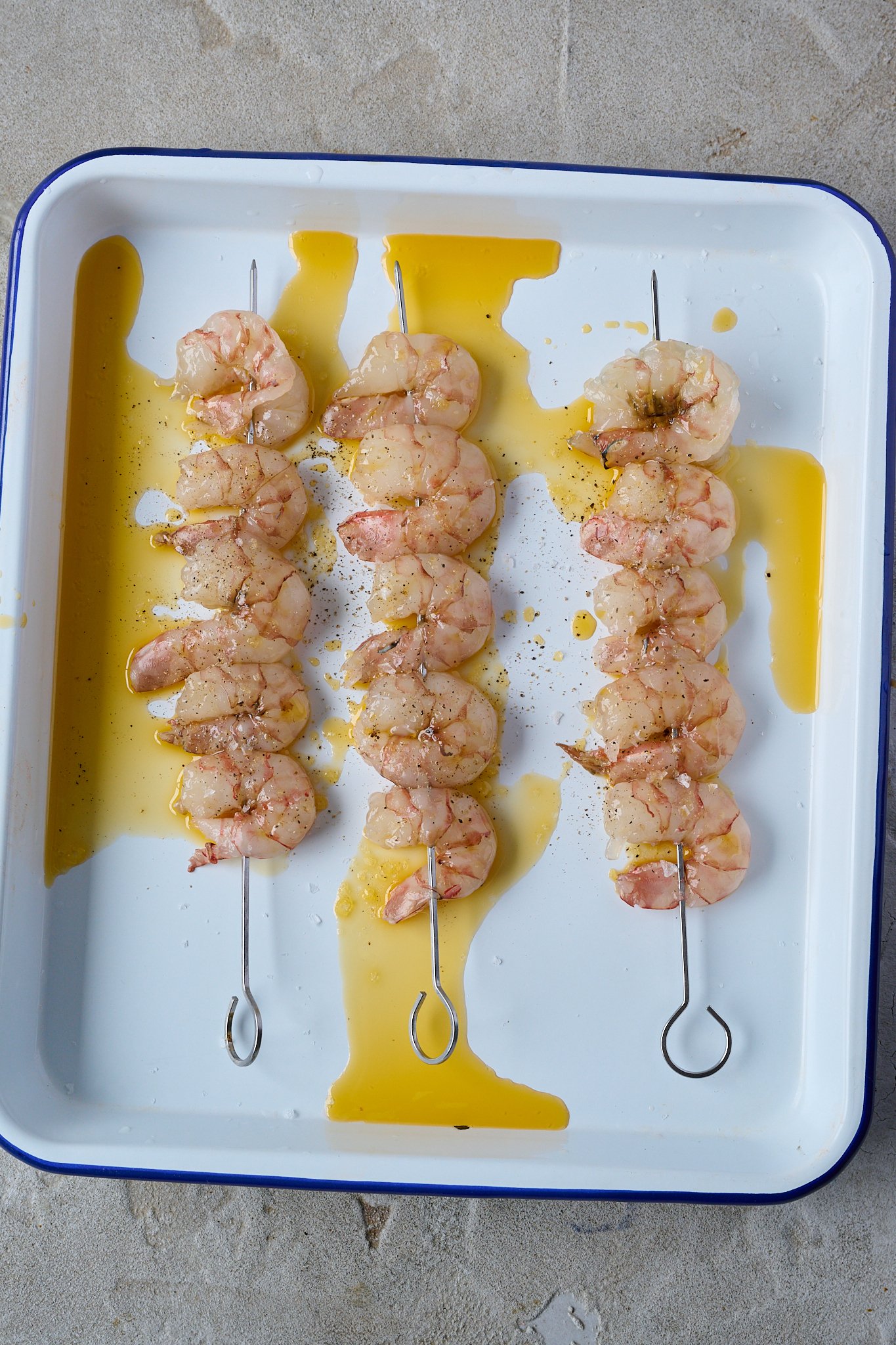 Prawns on platter have olive oil drizzled all over
