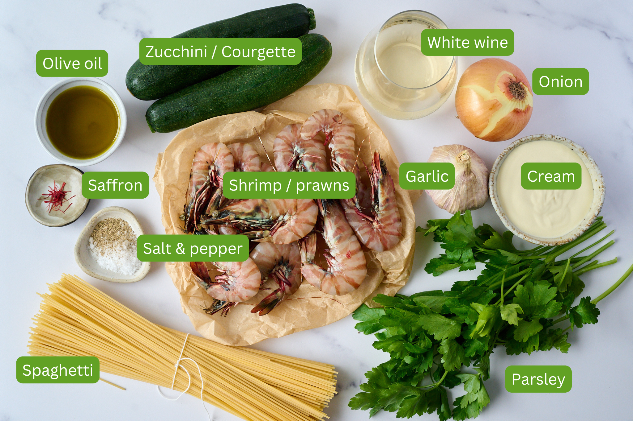 Ingredients for shrimp (prawn) and saffron spaghetti are shown. These include parsley, spaghetti, garlic, cream, prawns, salt and pepper, saffron, zucchini, onion, white wine