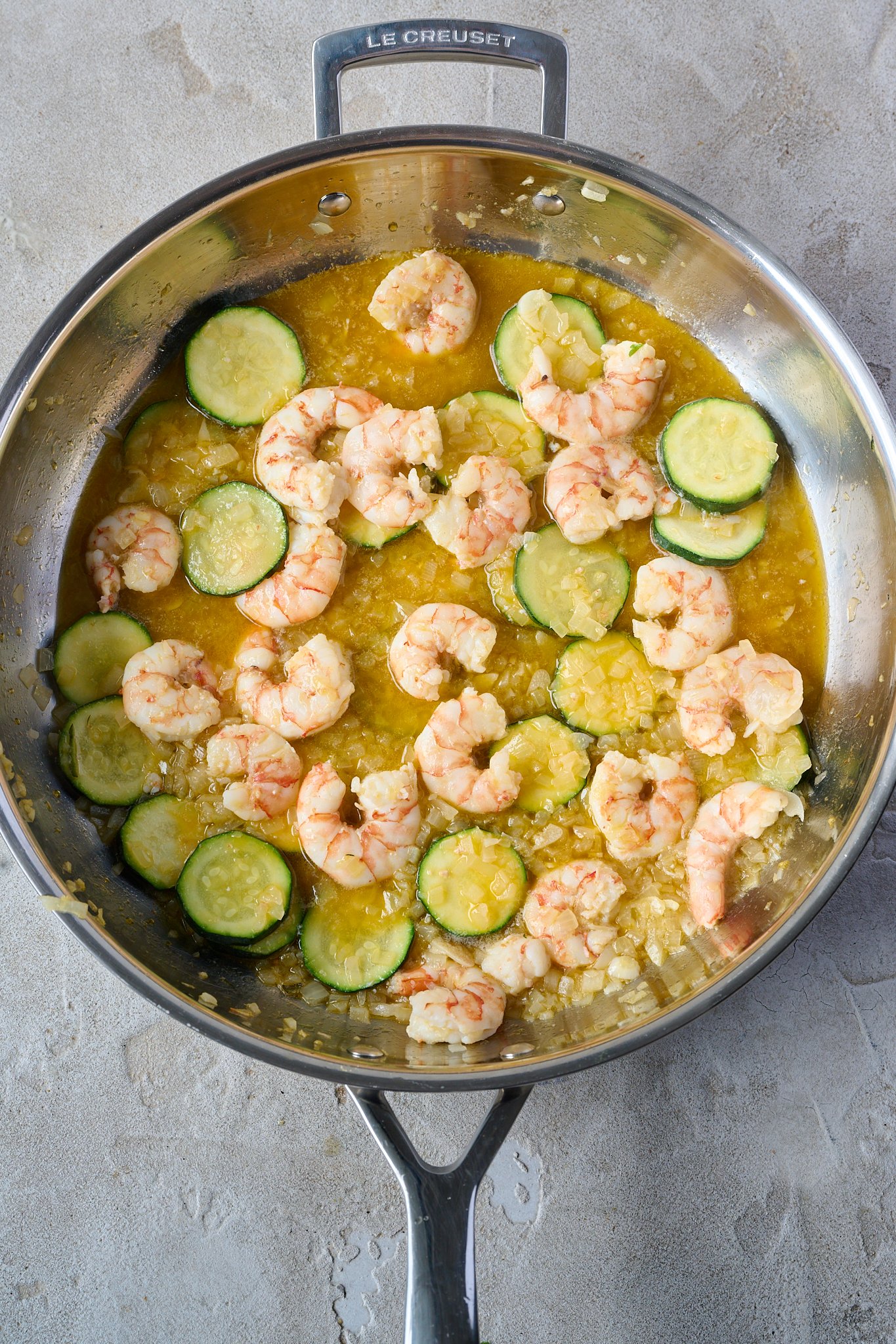 shrimp (prawn) and saffron spaghetti is in large fry pan and you can see prawns and zucchini
