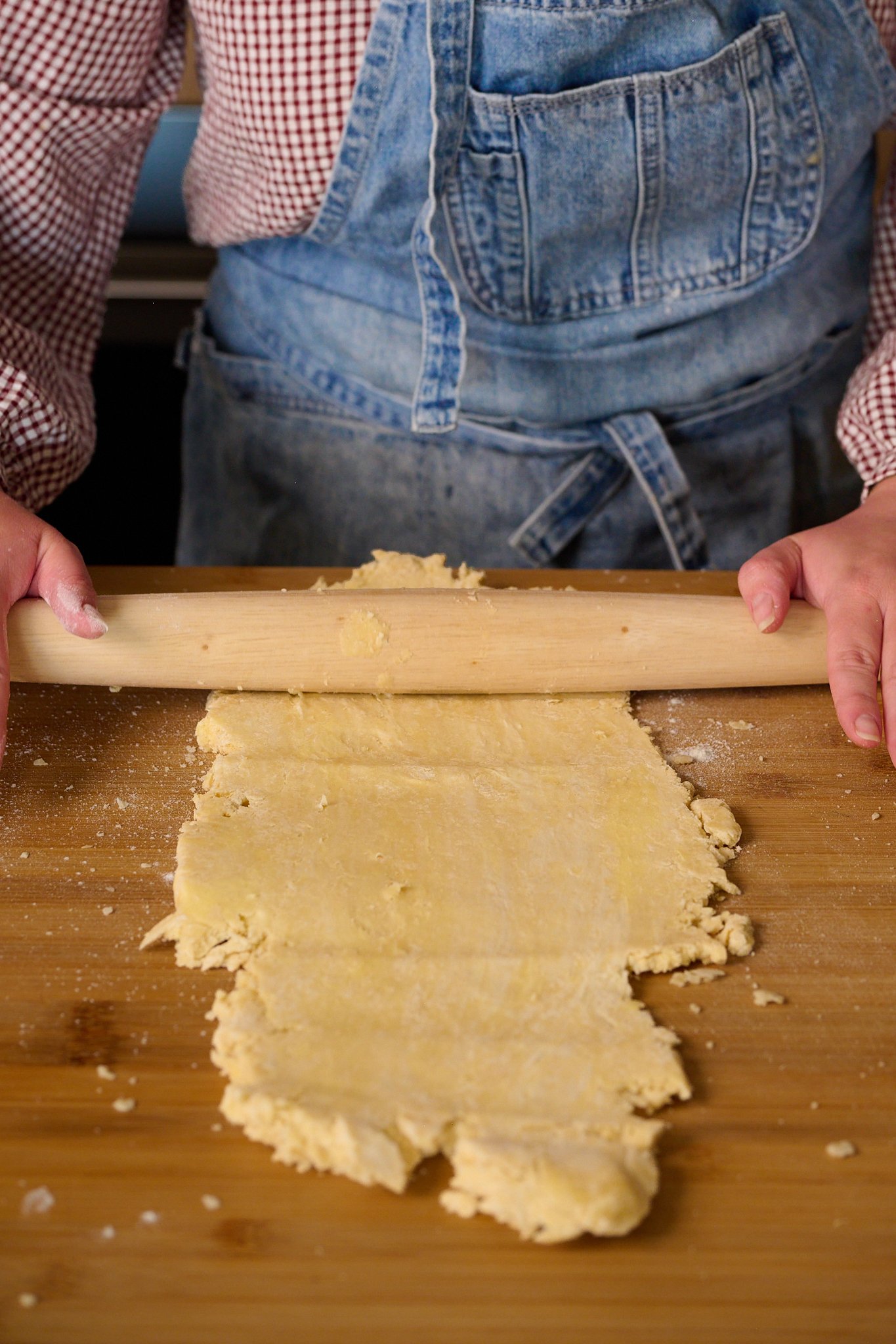 puff pastry is being rolled out with rolling pin.
