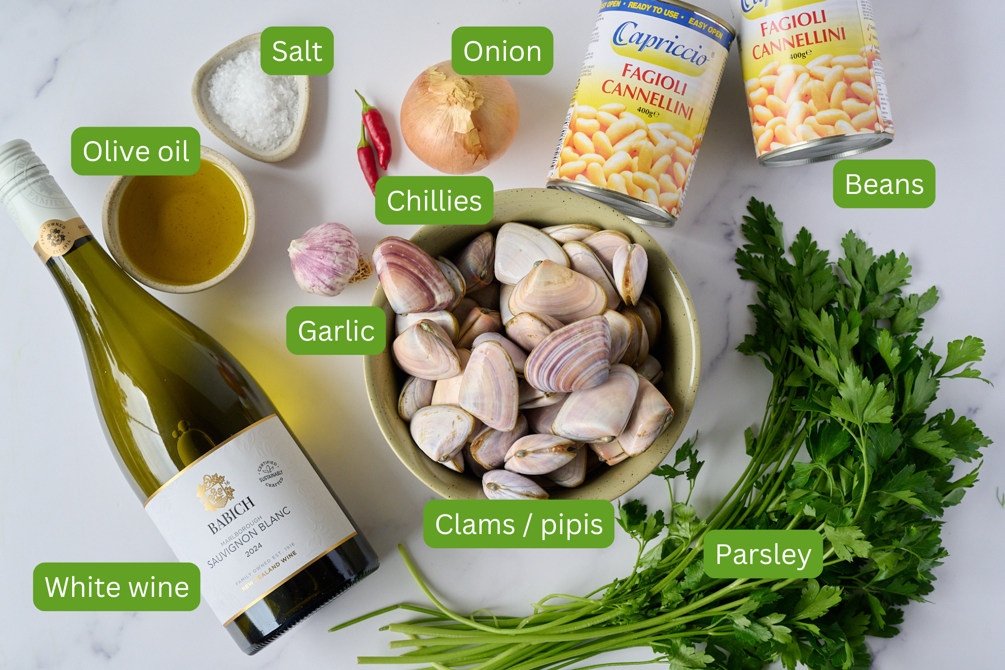 Ingredients for Spanish white bean and clam stew are shown. This includes white wine, olive oil, garlic, salt, chillies, onion, beans, parsley and clams.