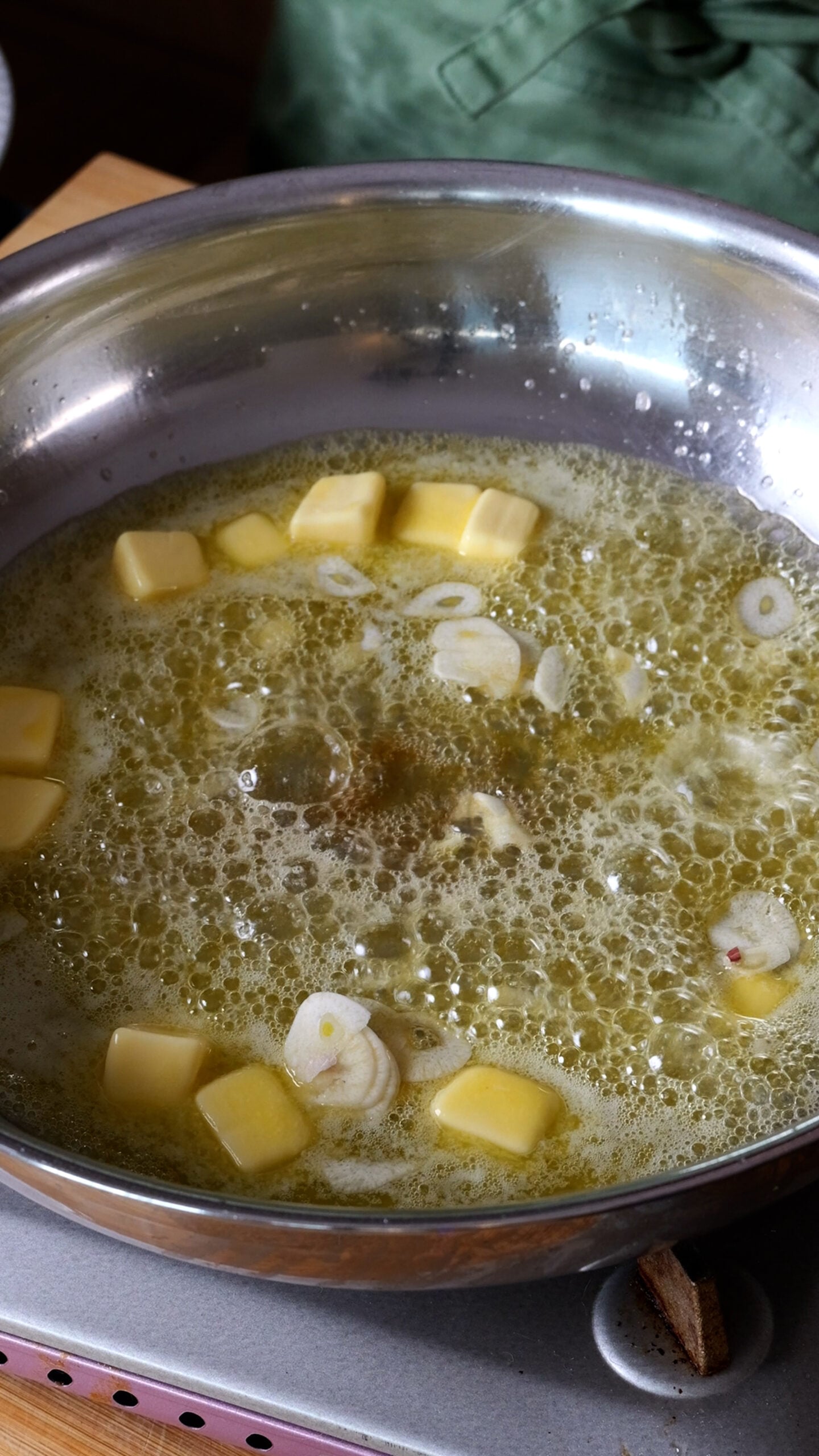 Butter is melted in large stainless steel pan.