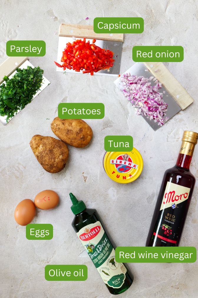 Ingredients shown for spanish potato salad including potatoes, eggs, red onion, parsley, capsicum, red wine vinegar, tuna and olive oil
