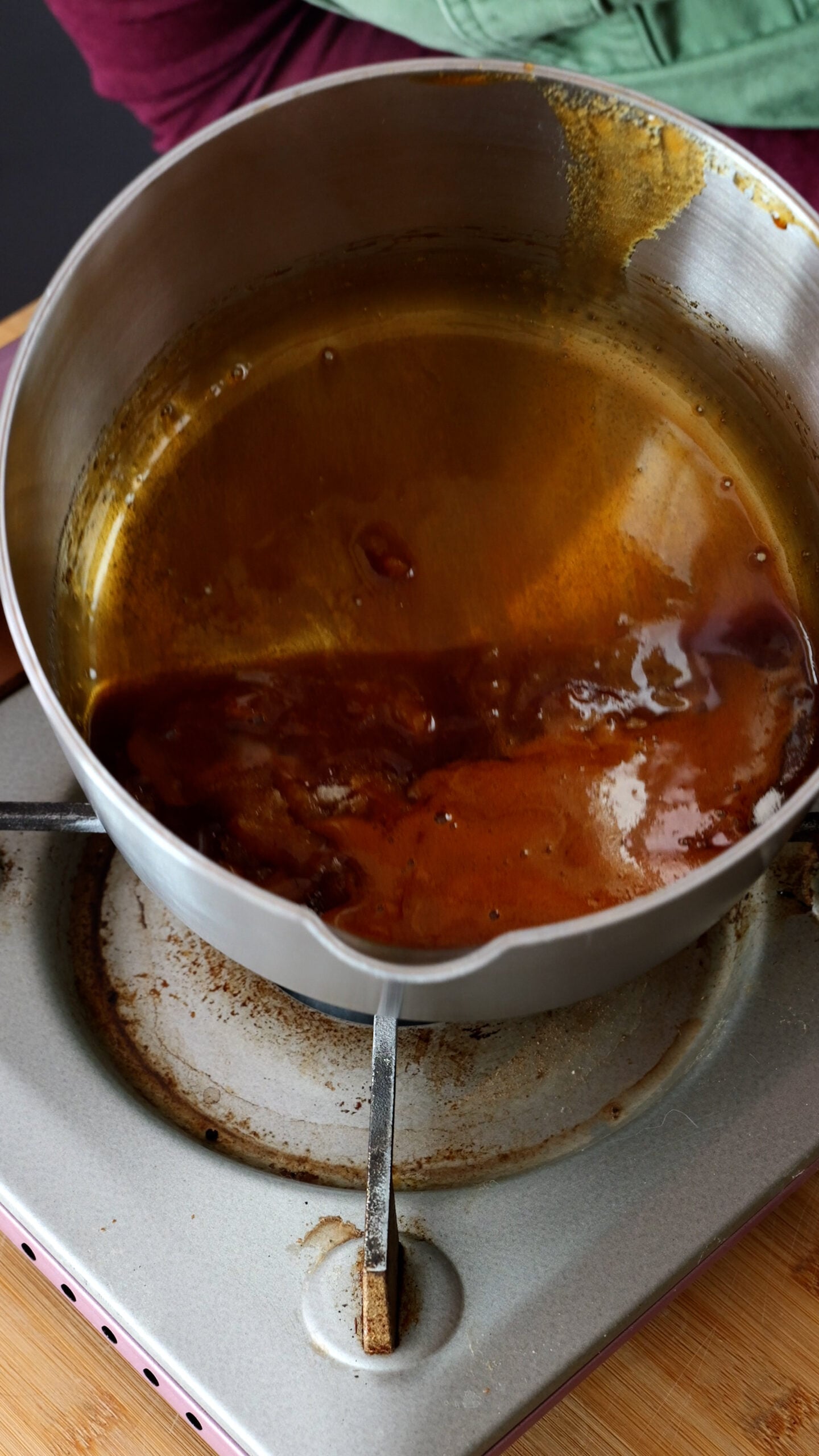 Large steel pot has amber coloured caramel in it